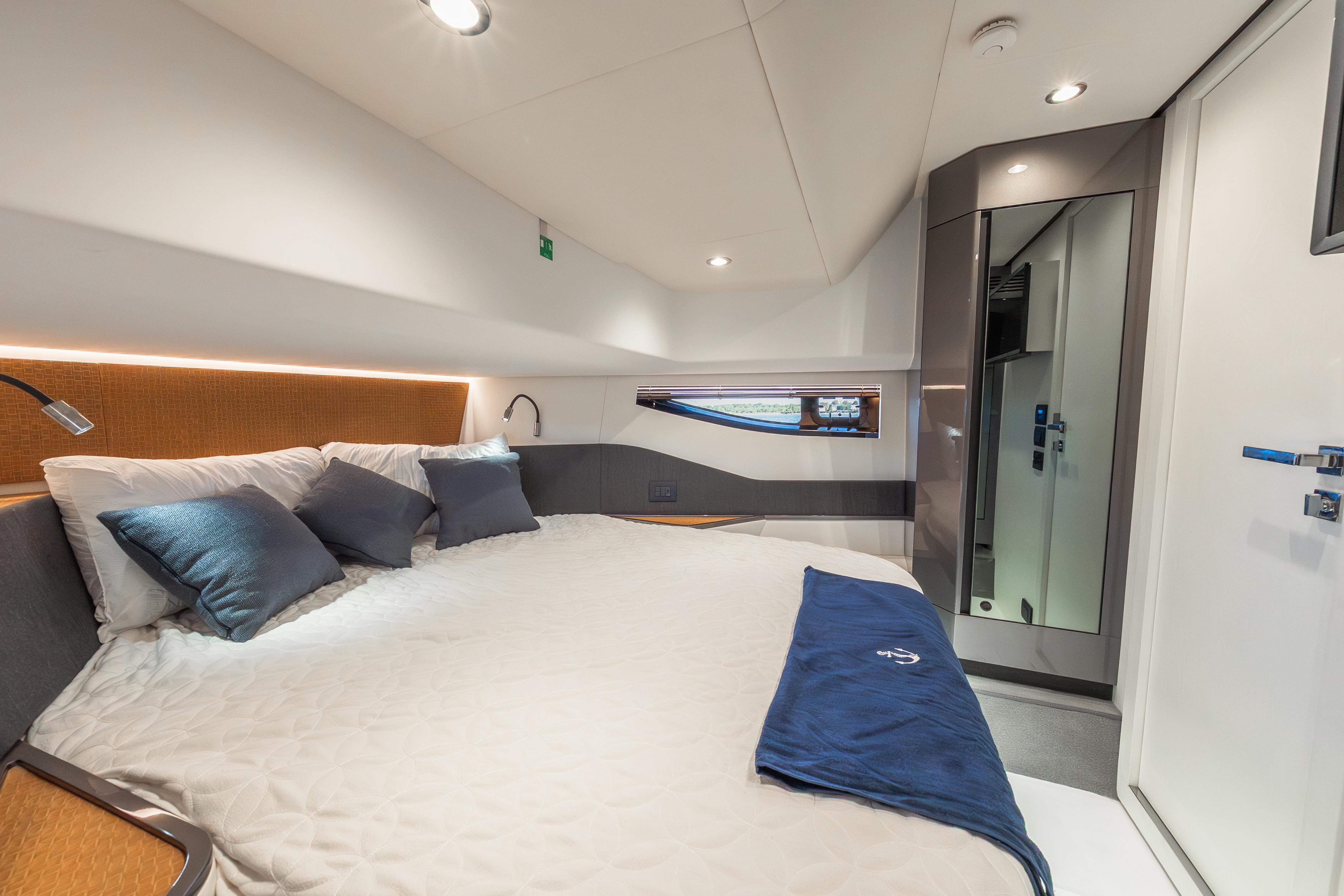 Luxurious cabin interior of 2023 Azimut Verve 47 yacht with modern design and cozy bedding.