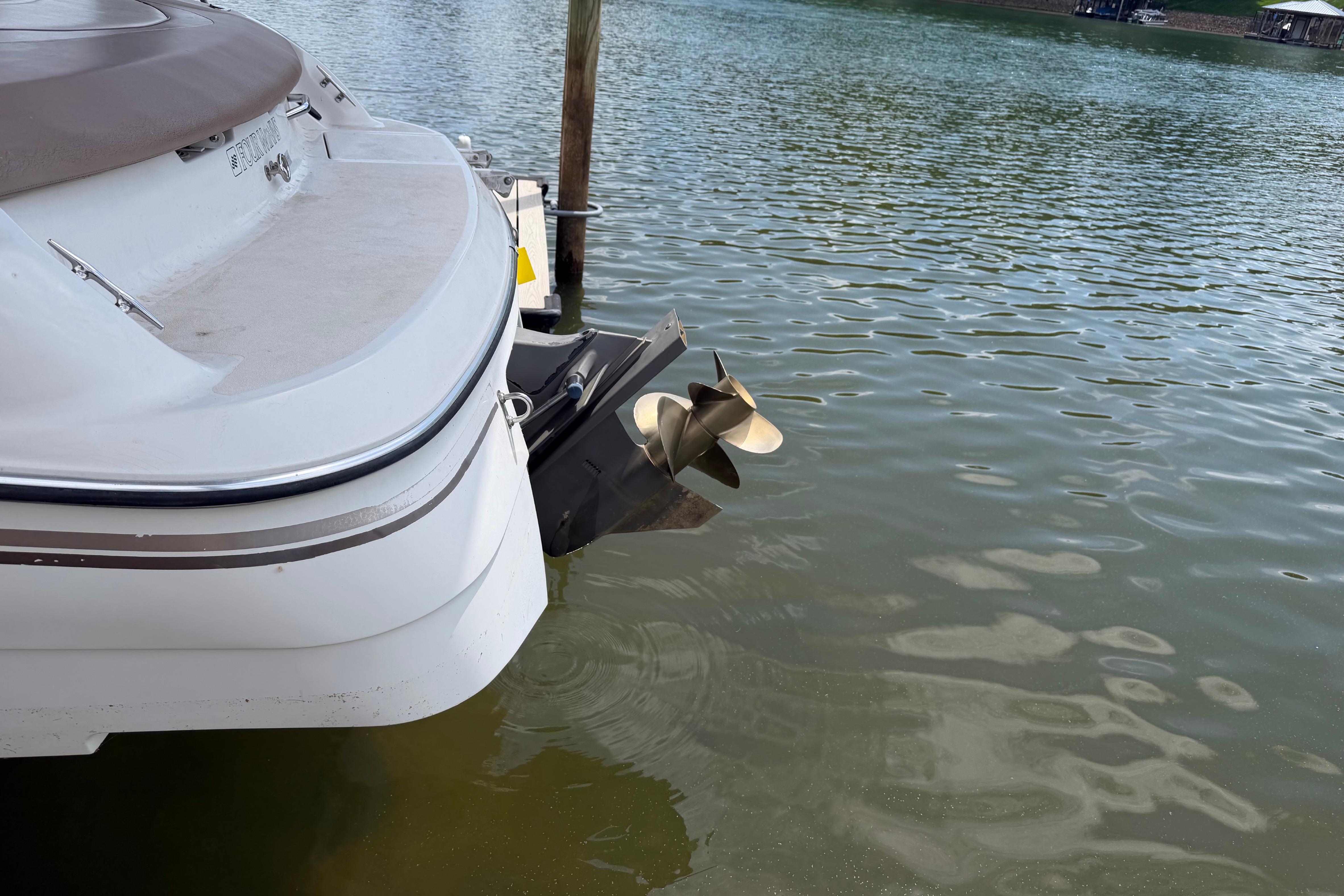 1998 Four Winns 220 Horizon boat stern and propeller on calm water.