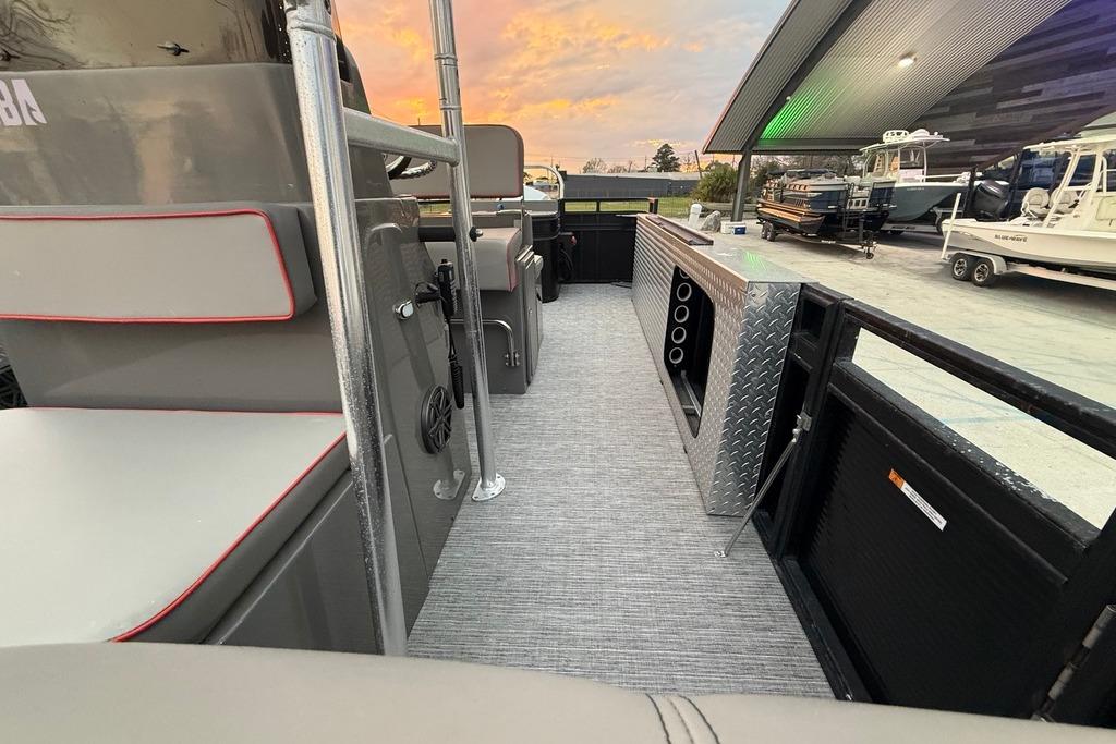 2022 Apex Marine 8524 Pro Fish N Cruise interior with seating and storage, under a sunset sky.