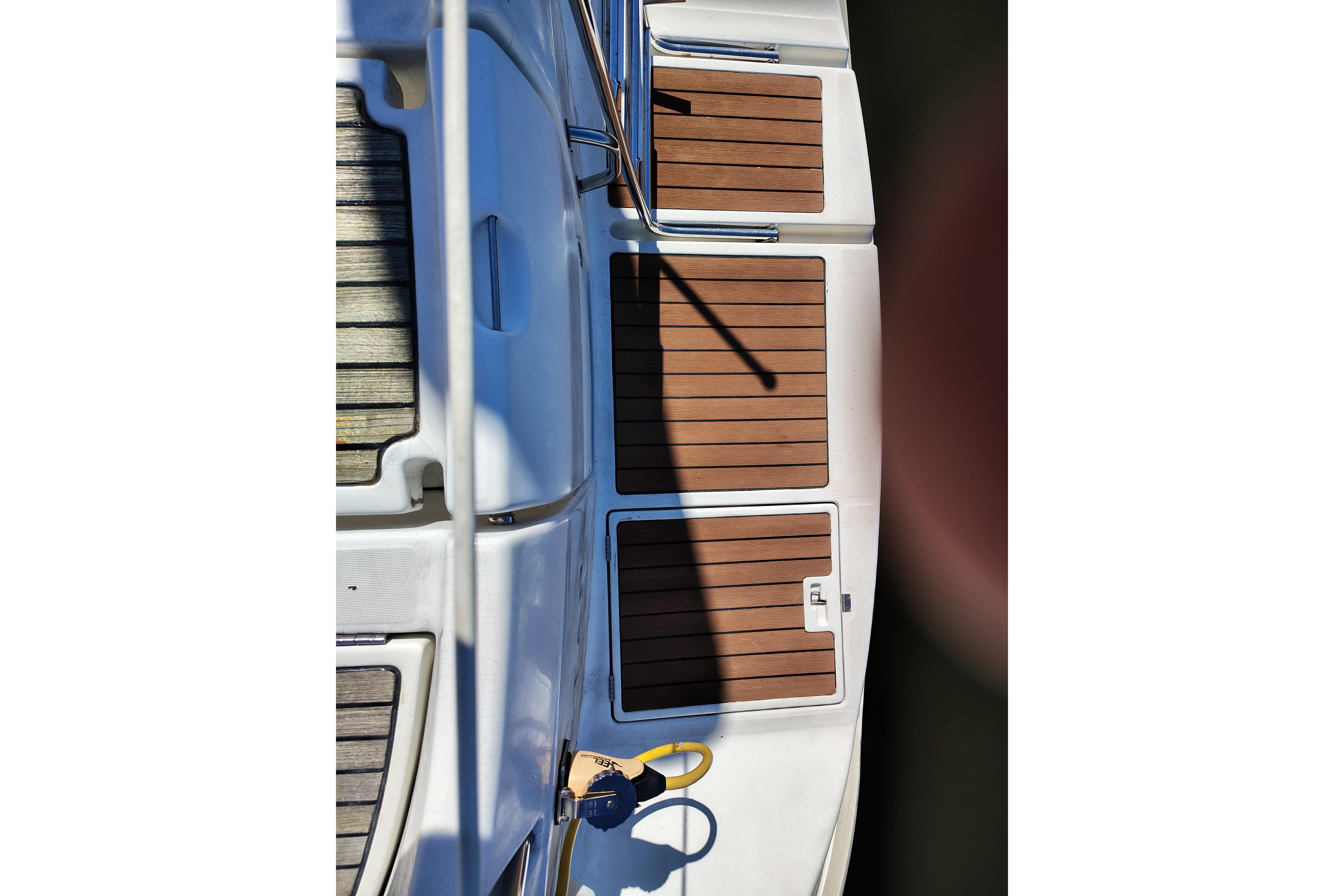 Deck view of 2001 Beneteau Oceanis 411 sailboat with teak flooring and white accents.