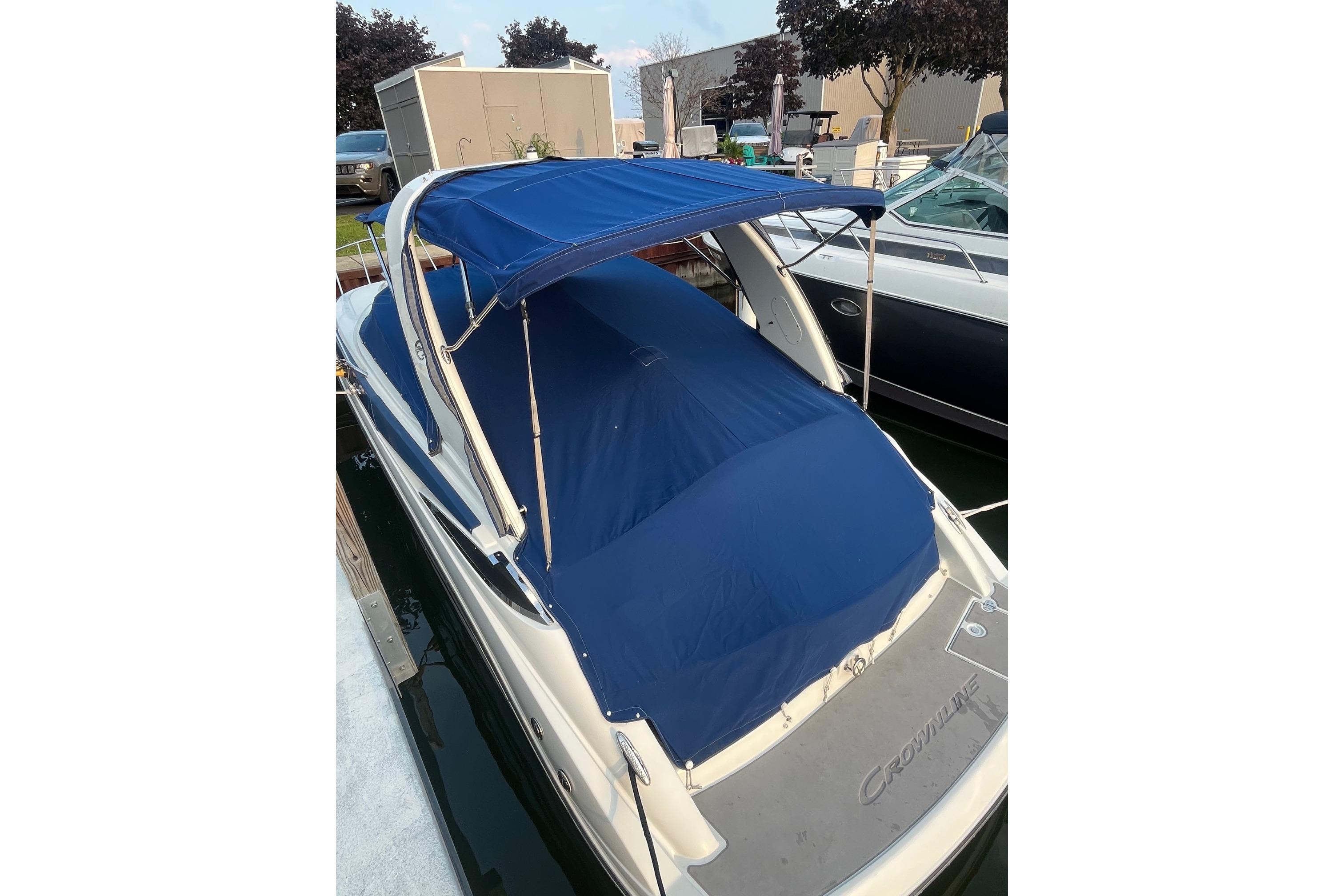 2016 Crownline 264 CR boat with blue cover and canopy docked at marina.
