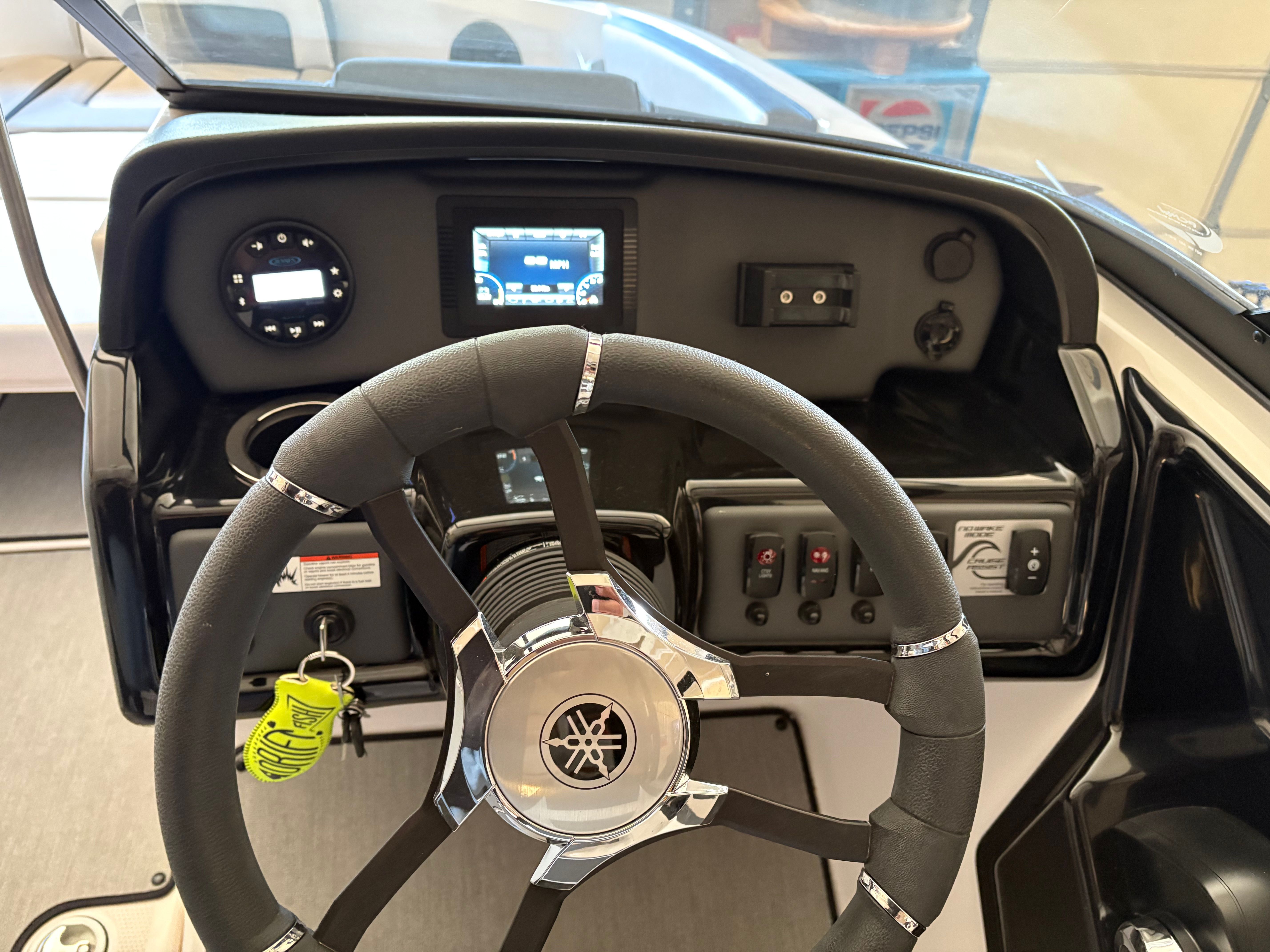 The cockpit of a Yamaha AR195 boat with steering wheel and dashboard.