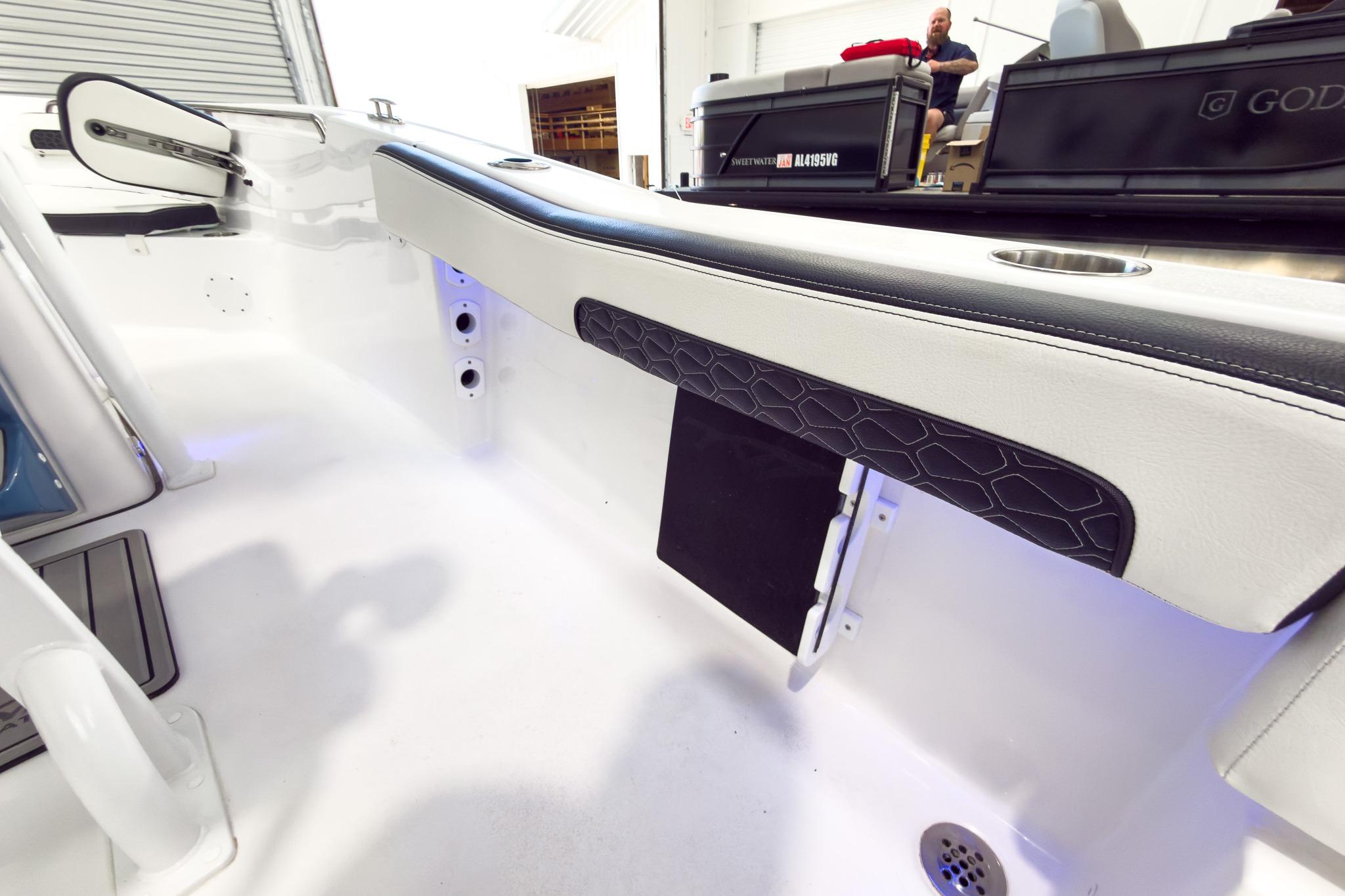Interior view of a boat with white and black upholstery and stainless steel details.