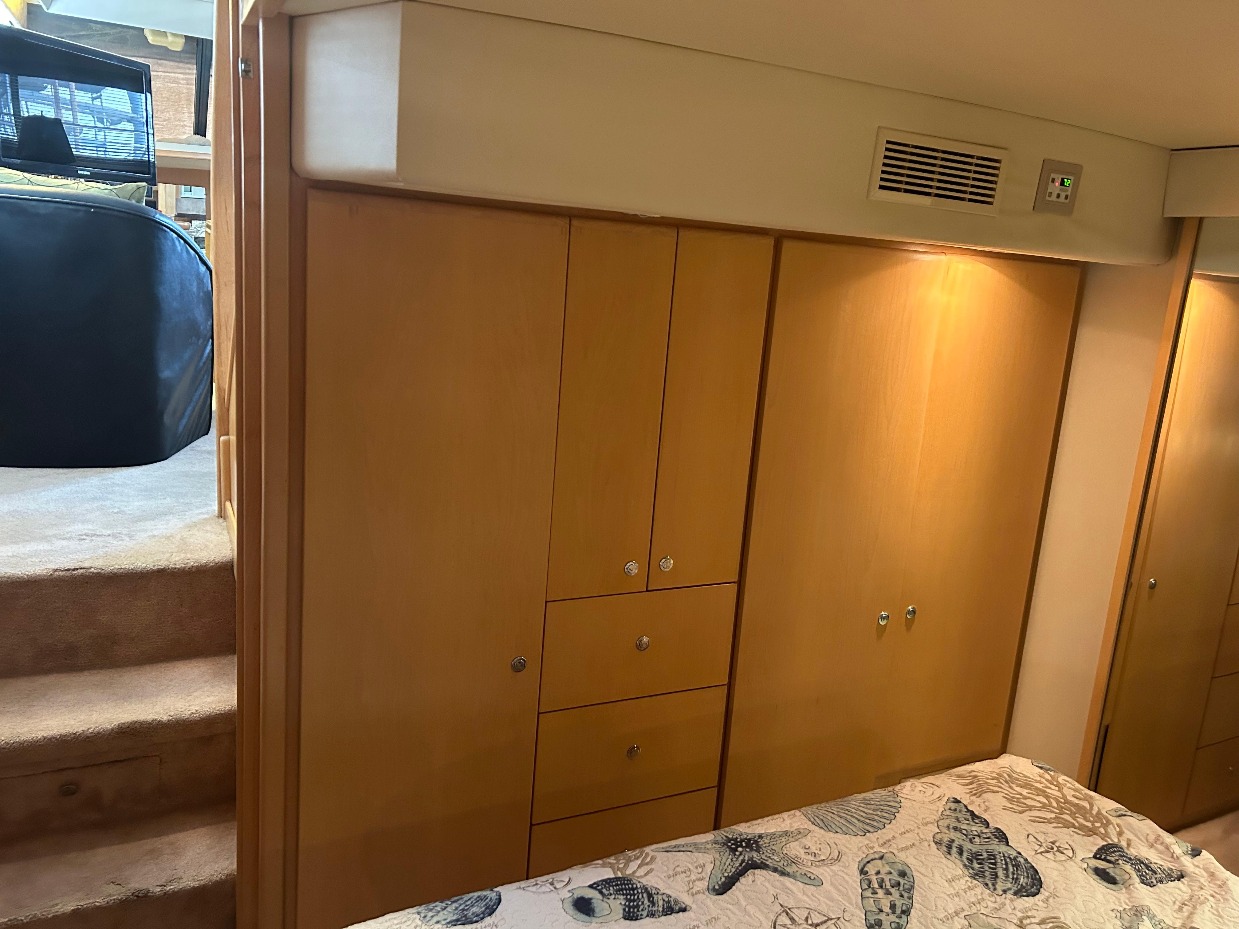 1996 Carver 440 Aft Cabin Motor Yacht interior with wooden cabinetry and patterned bedding.