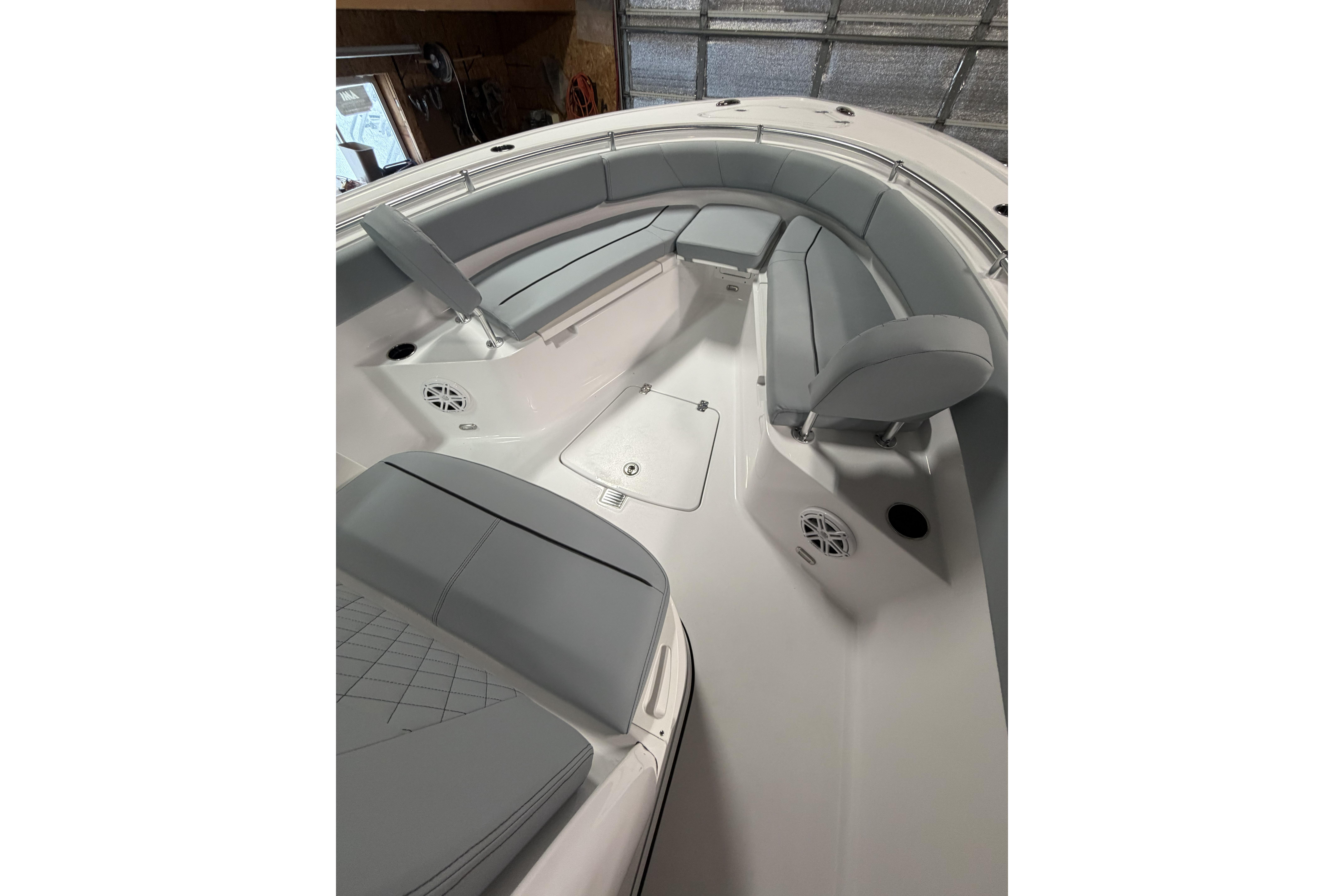 2026 Sportsman Open 232 Center Console boat interior with cushioned seating and storage compartments.