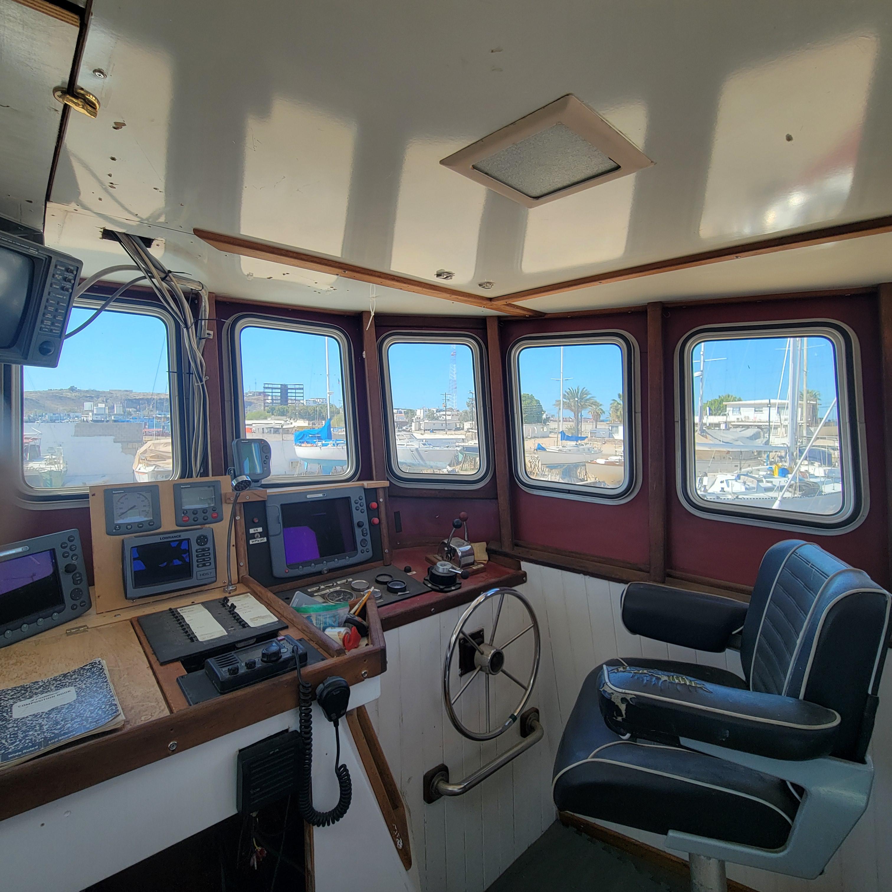 1979 Shrimper Conversion Trawler cockpit with navigation equipment and panoramic windows.
