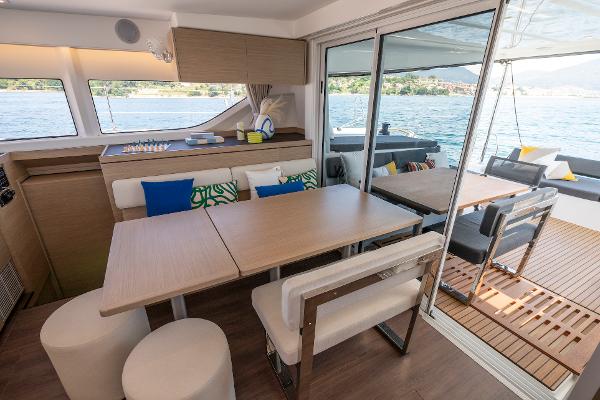 Luxurious interior of 2025 Lagoon 43 yacht with dining area and scenic water view.