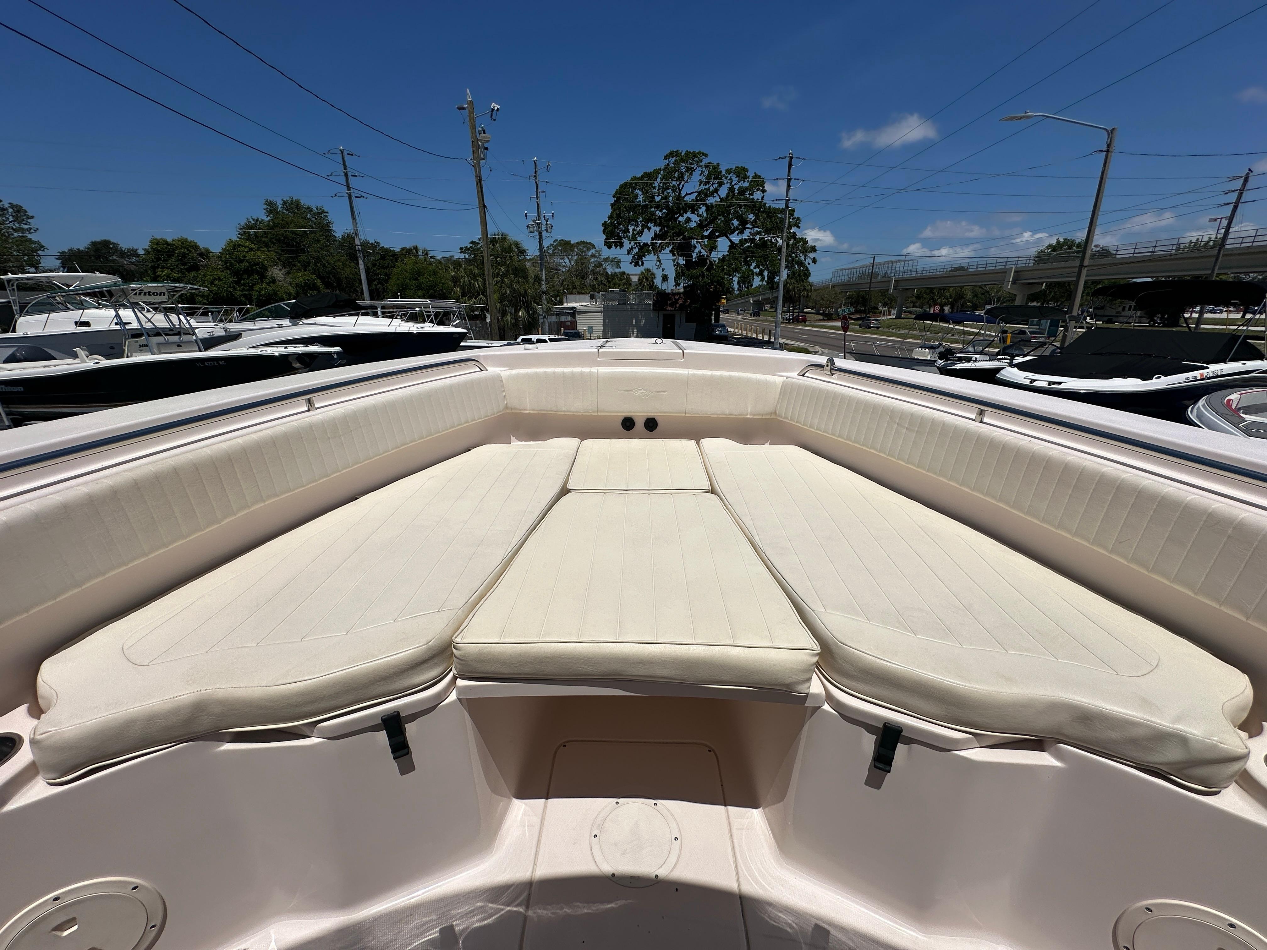 2013 Grady-White Canyon 306 boat with spacious cushioned seating under a clear blue sky.