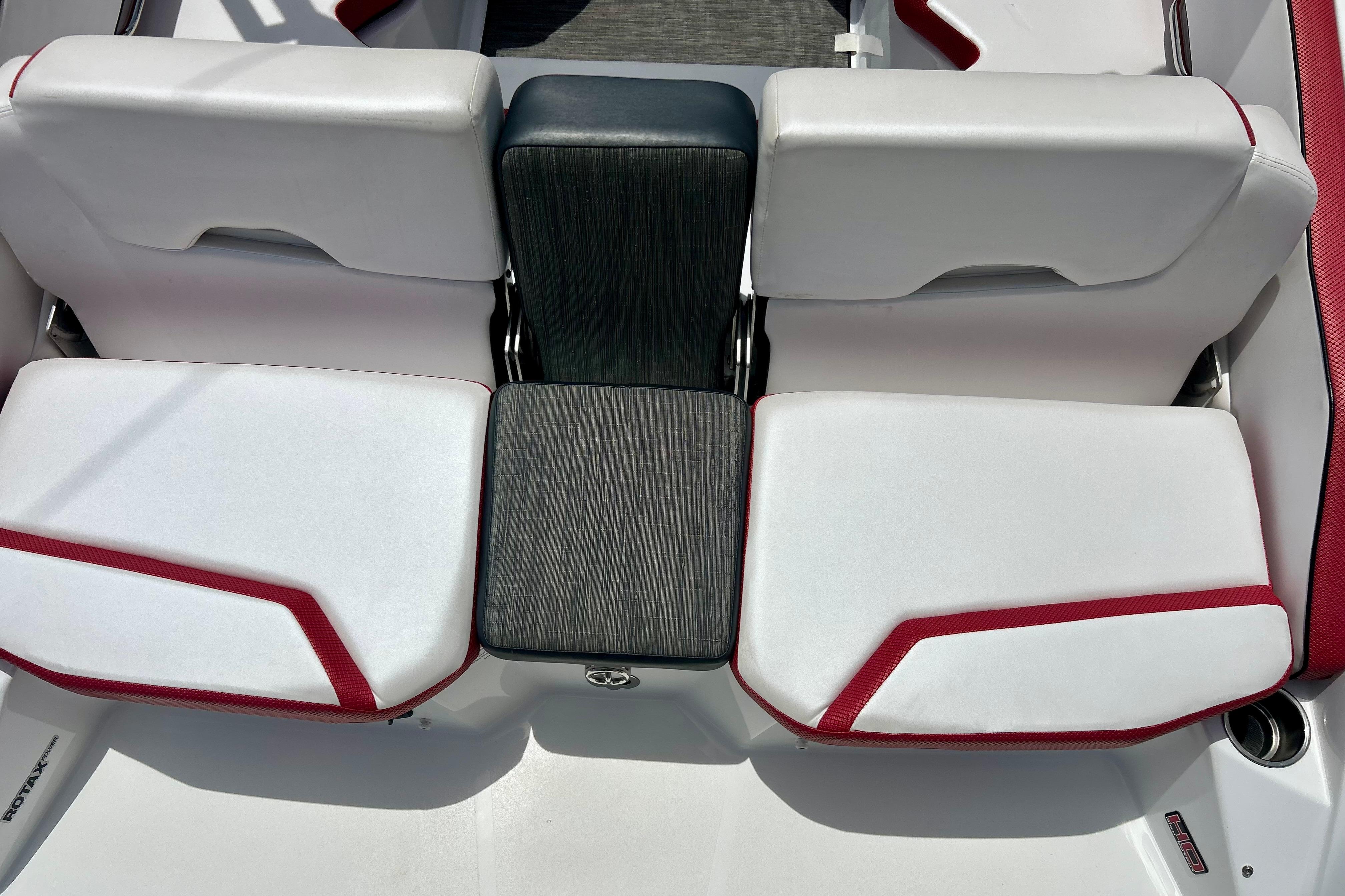 2021 Scarab 195 ID boat interior with white and red seating, featuring a central black cushion.