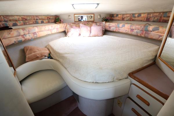 1992 Sea Ray 350 Express Bridge cabin with cozy bed and seating area.