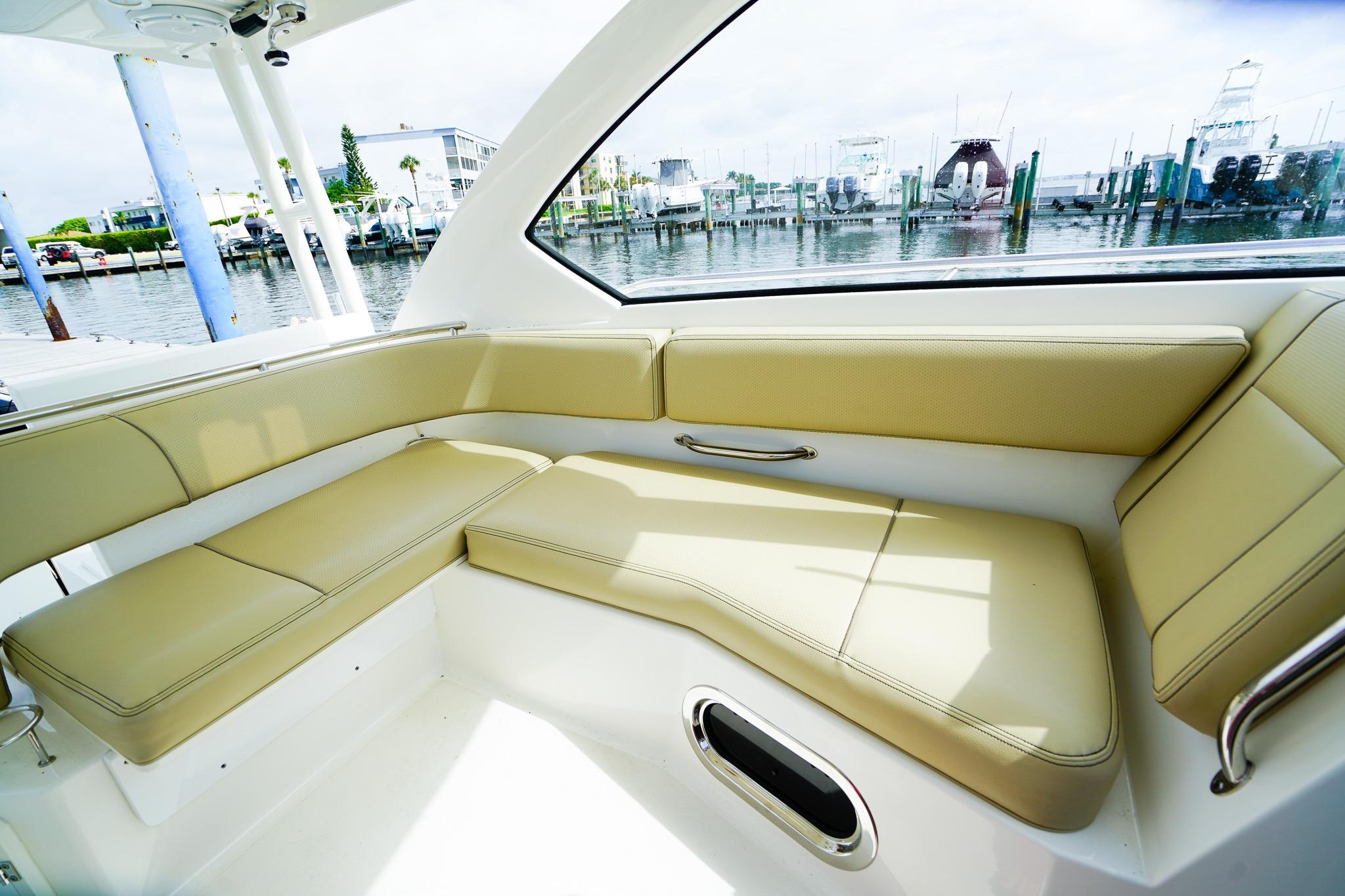 Luxurious seating area on 2020 Pursuit OS 325 Offshore boat, docked at marina.