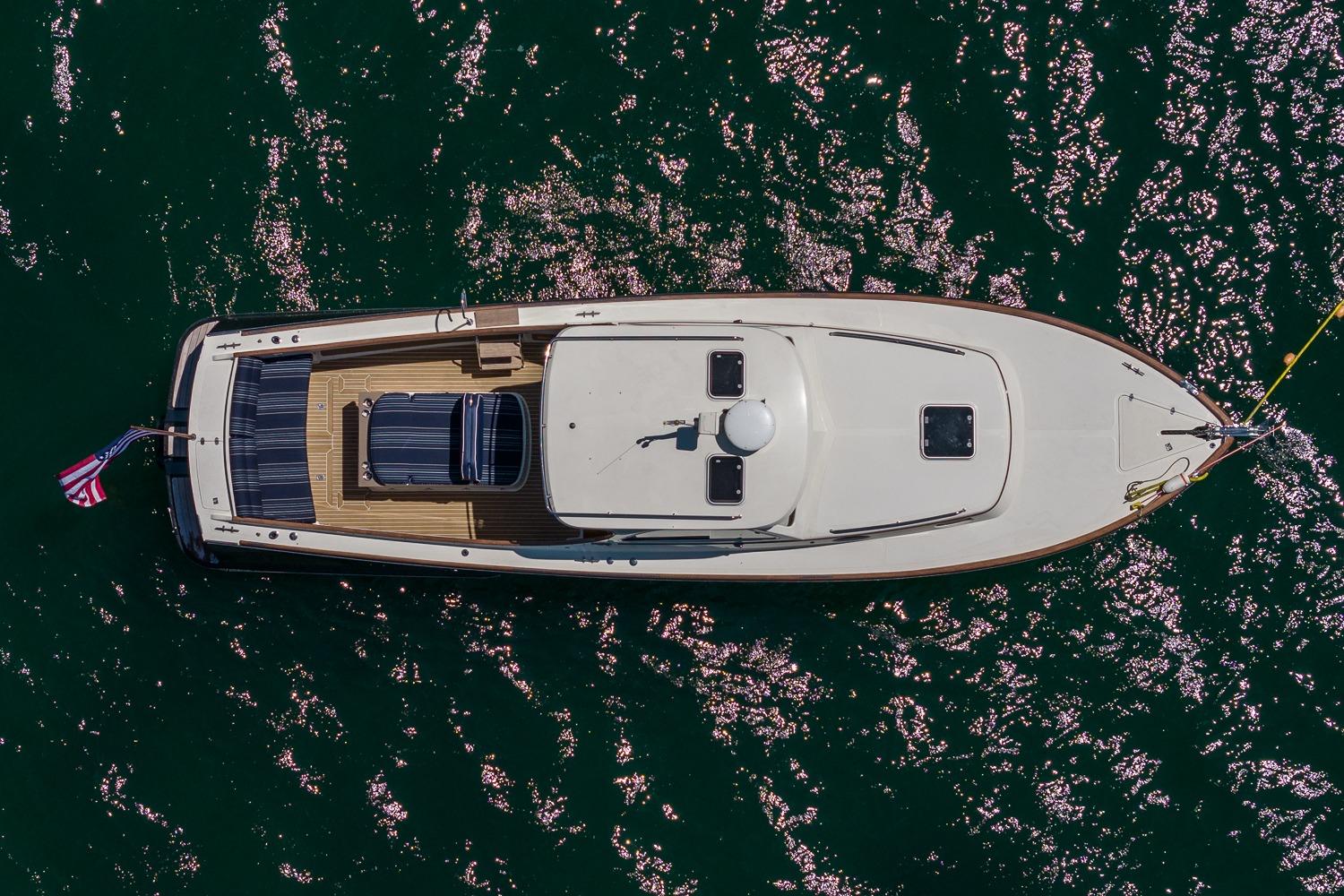 Aerial view of 2001 Hinckley Picnic Boat 36 Classic on sparkling water.