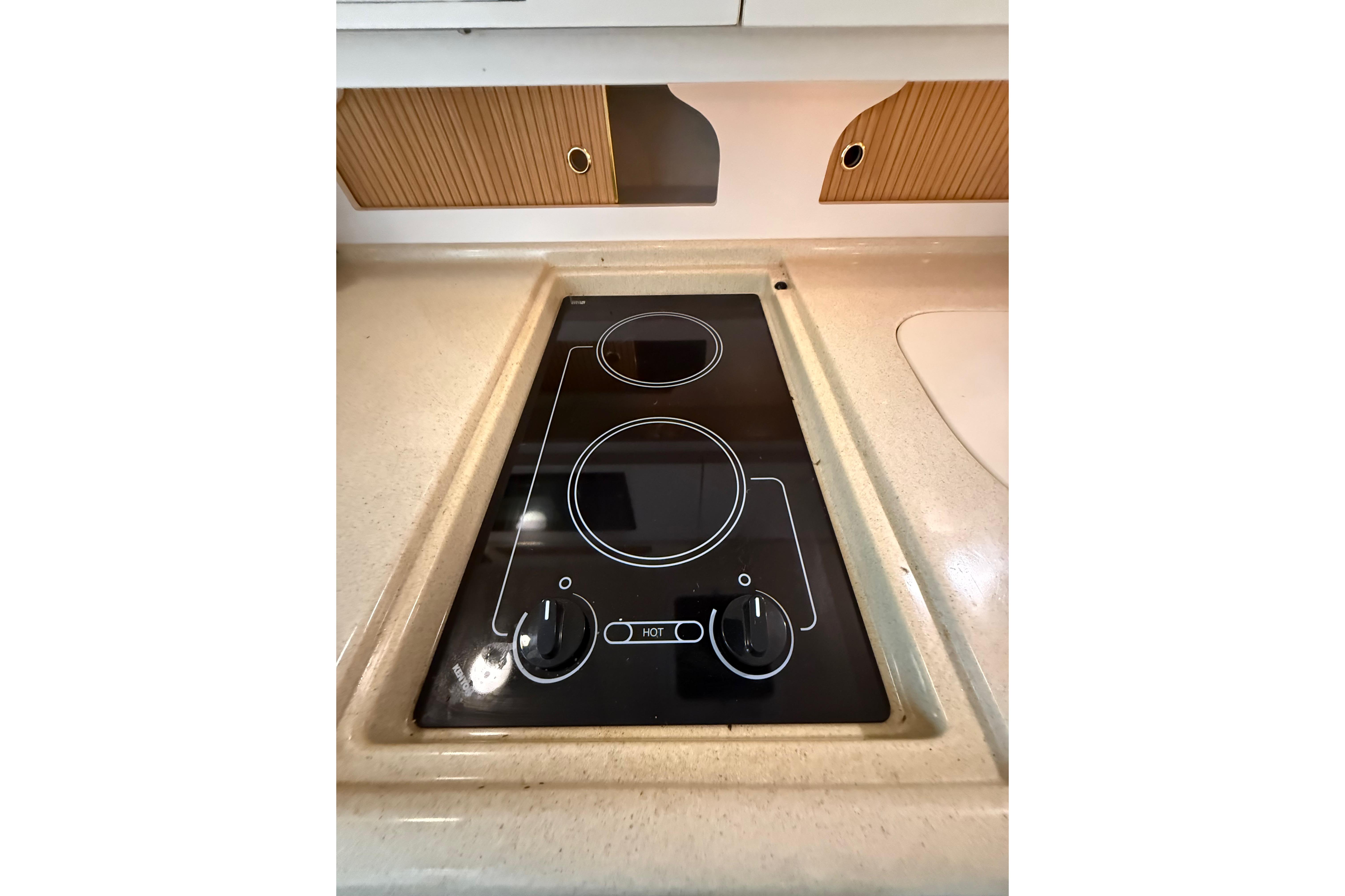1999 Sea Ray Sundancer 310 stovetop with two burners in a compact kitchen setting.