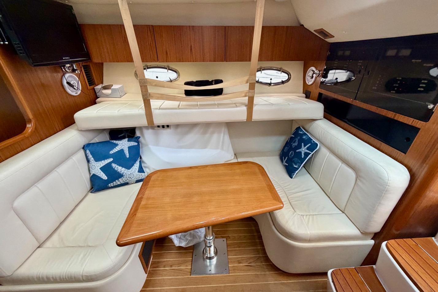 Interior of 2003 Tiara Yachts 3500 Open with cozy seating and wooden table.