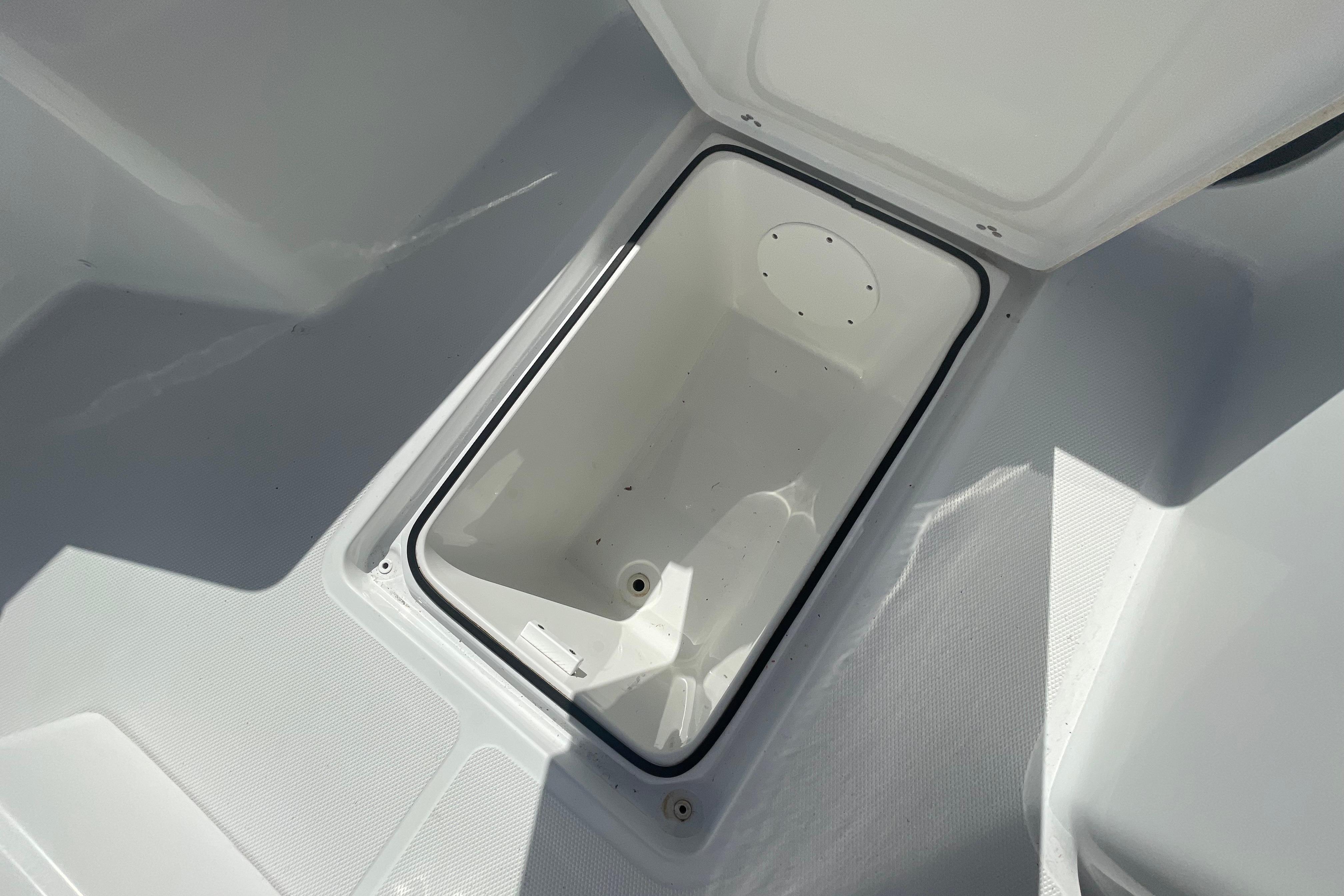 Open storage compartment on 2022 Wellcraft 202 Fisherman boat, showcasing interior space.