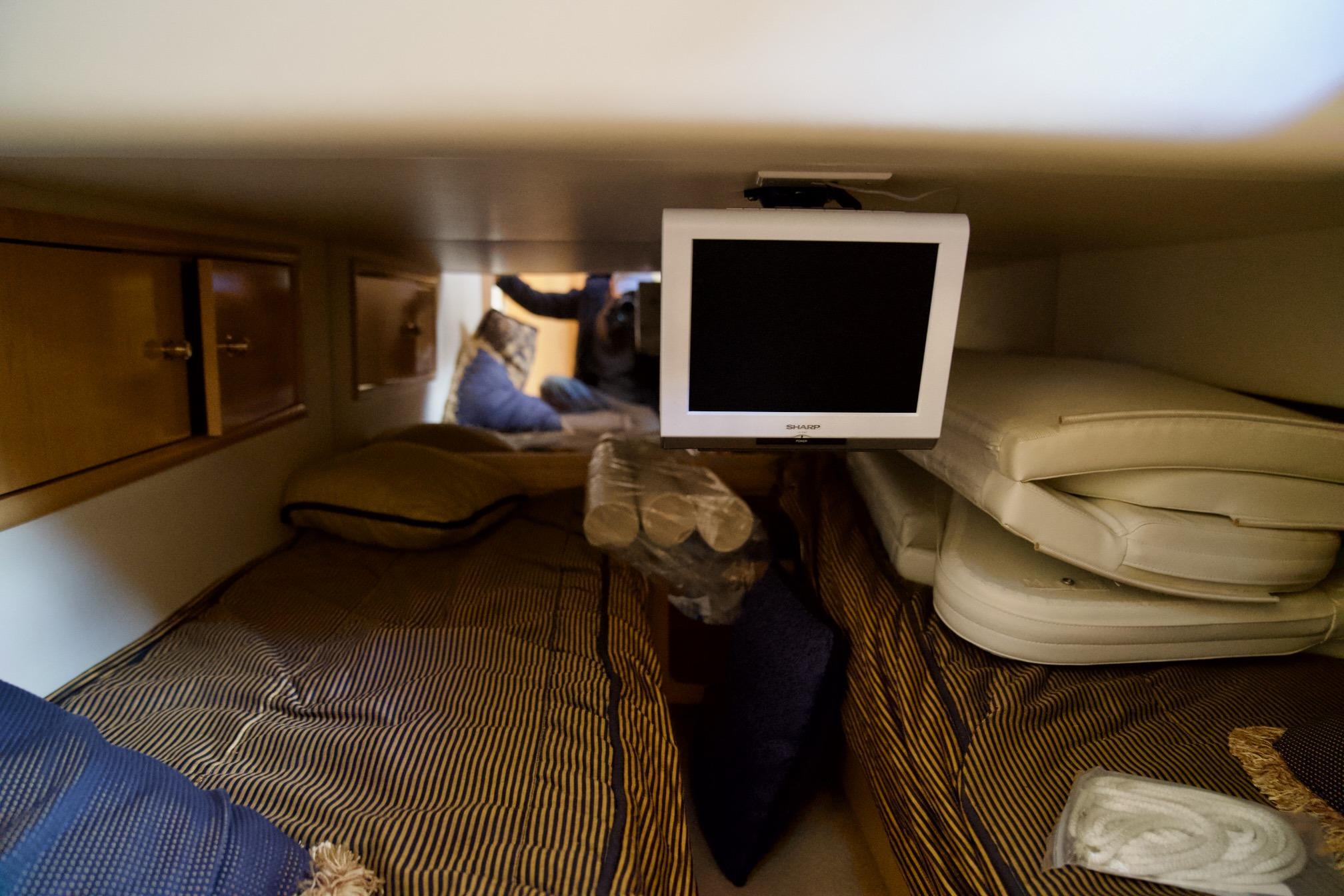 Interior cabin of 2000 Carver 506 Motor Yacht with beds and TV.