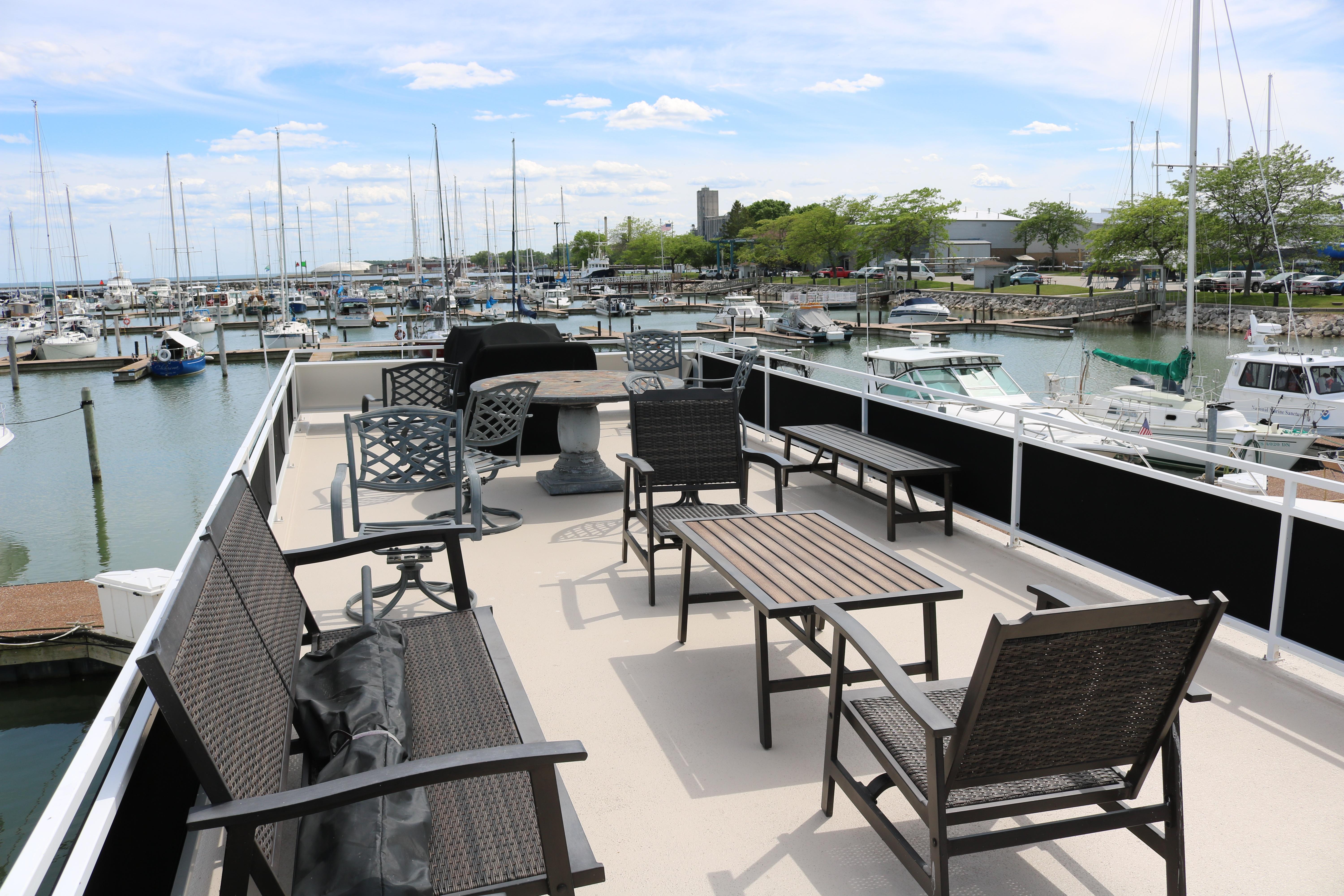 Flybridge deck of 2010 Skipperliner 480, overlooking marina with seating and tables.