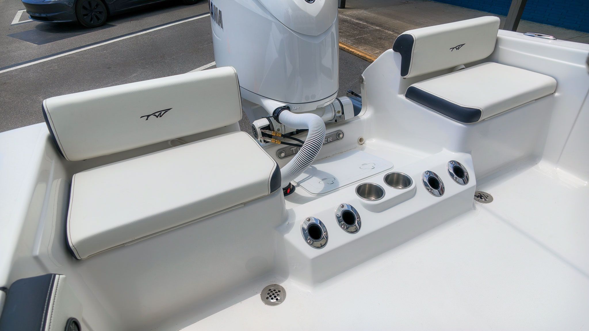 The image shows the interior of a Tidewater 198 CC Adventure boat with white seating and cup holders.
