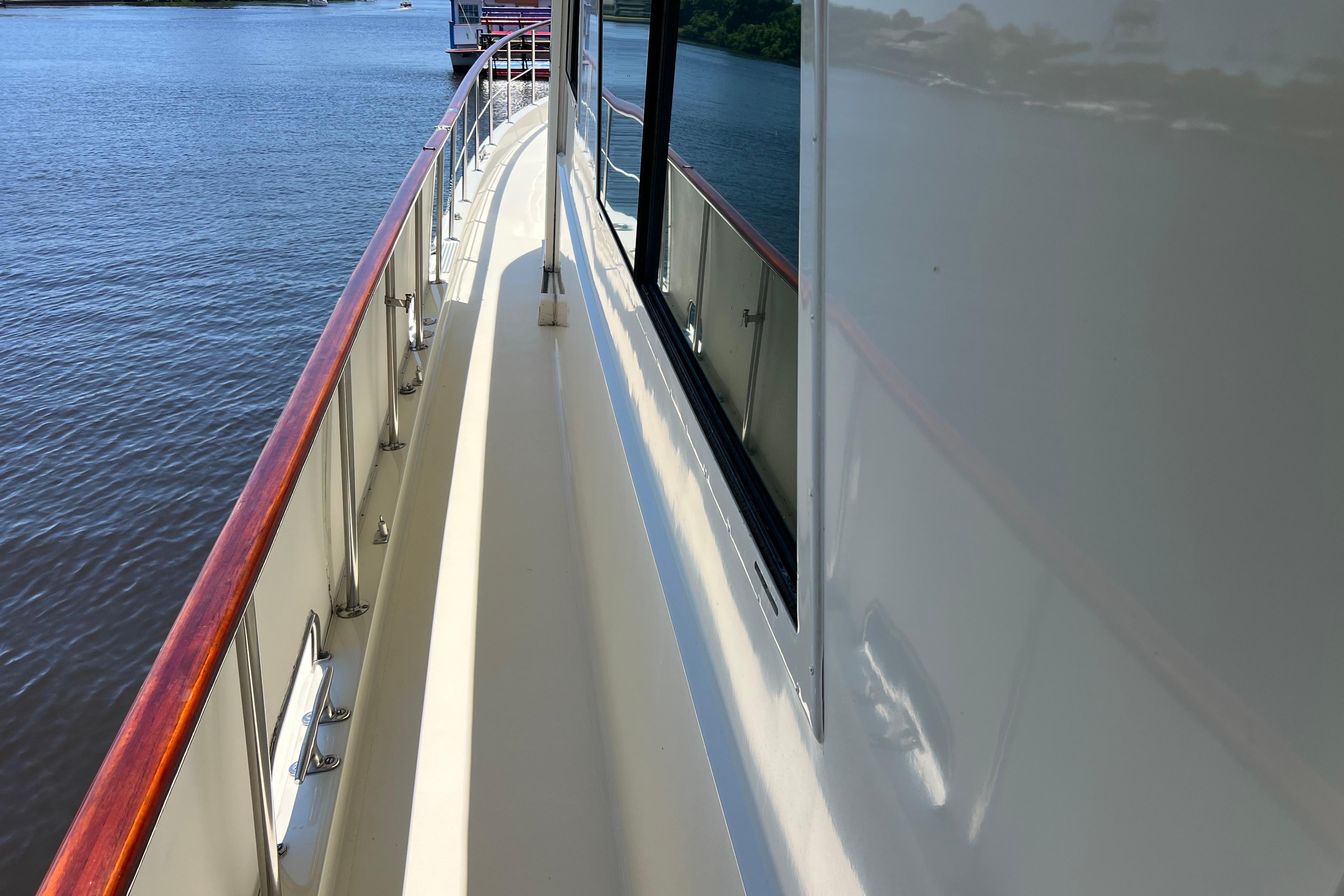 Side deck view of 1987 Hatteras 70 Cockpit Motor Yacht on calm water.