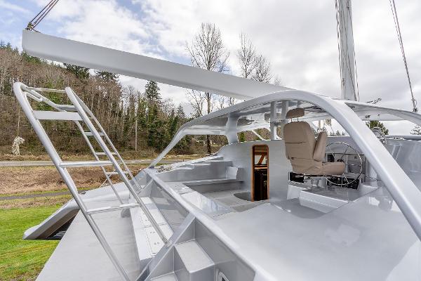 2025 Shuttleworth 52 AeroRig yacht with sleek design and modern cockpit, set against a wooded backdrop.