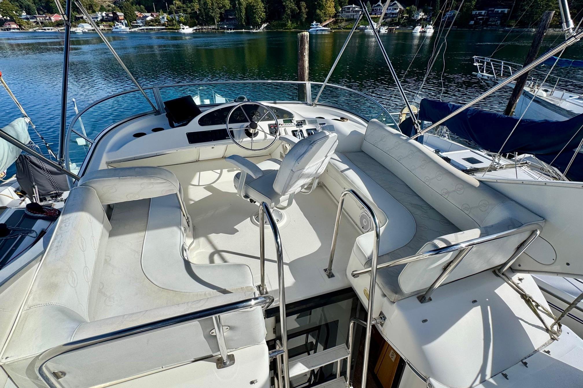 1998 Bayliner 3388 Command Bridge Motoryacht with spacious seating and scenic waterfront view.