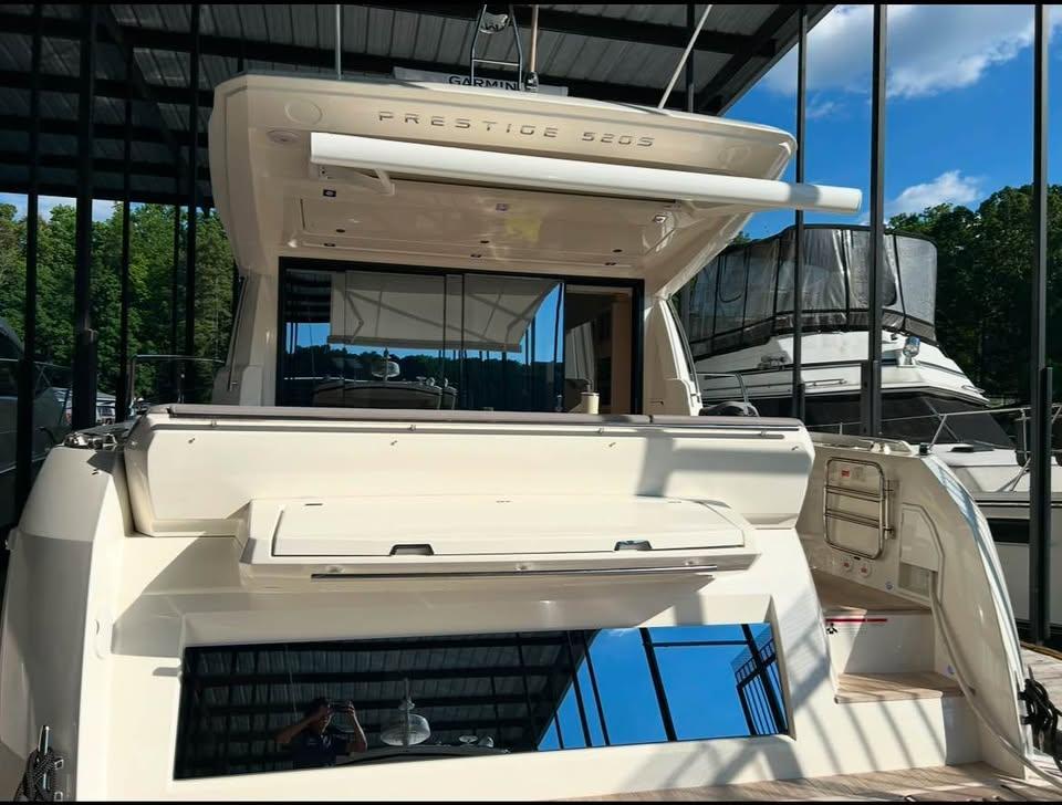 2023 Prestige 520S yacht docked under a canopy, showcasing sleek design and modern features.