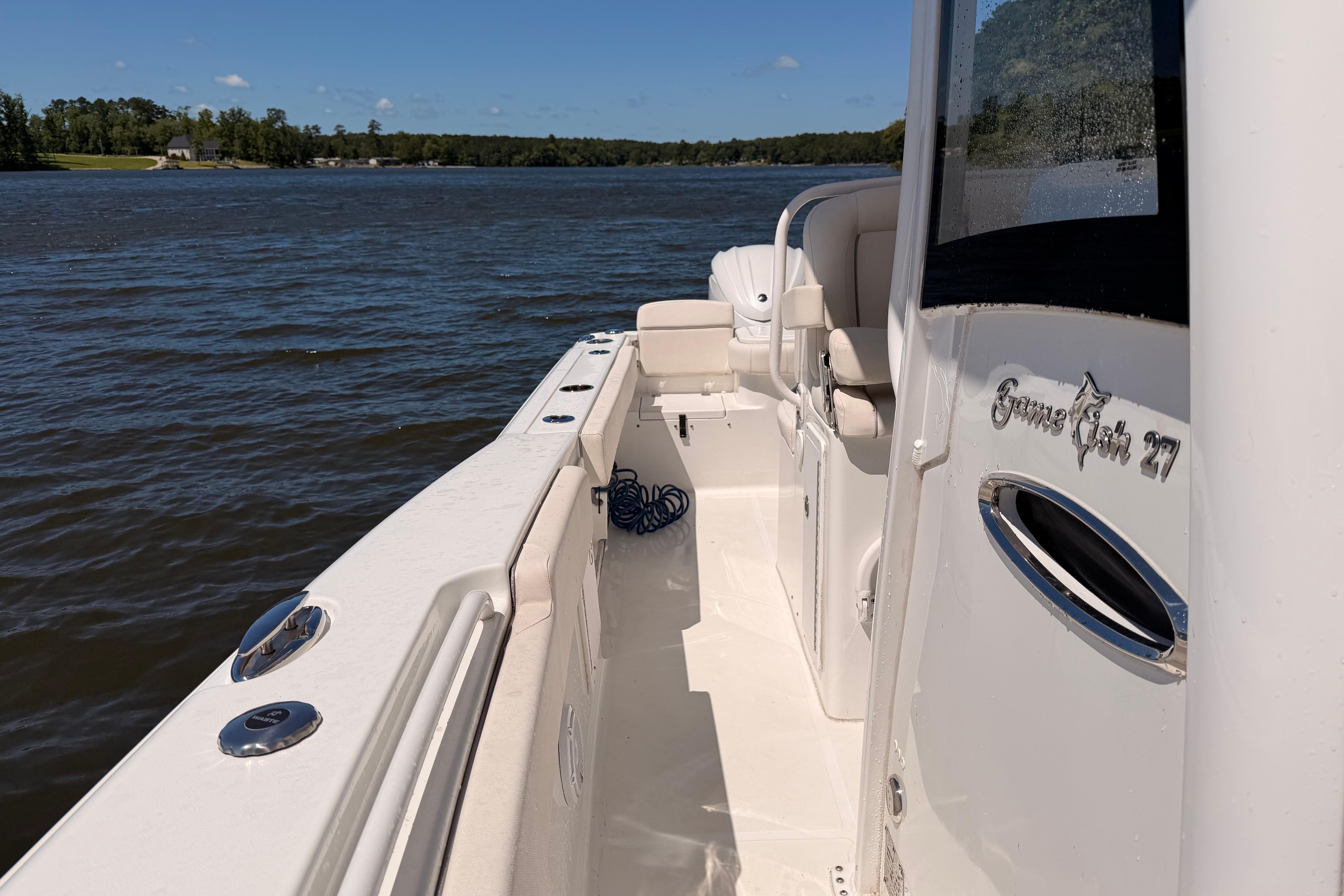 2024 Sea Hunt Gamefish 27 Coffin Box boat on calm water, side view.