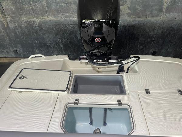 2024 Mako Pro Skiff 19 CC boat stern with storage compartments and outboard motor.
