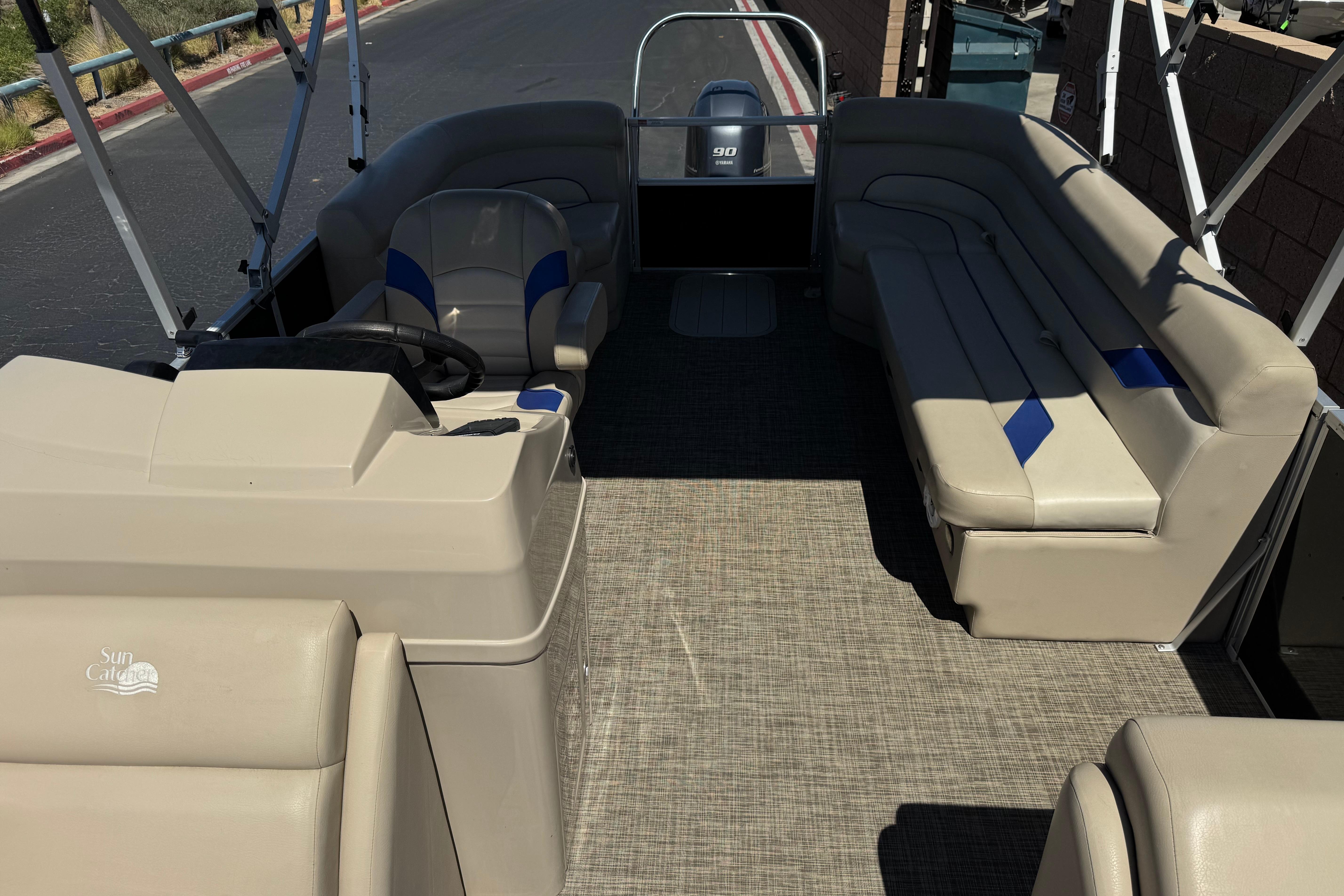 2021 SunCatcher Select 20RCX pontoon boat interior with beige seating and steering console.