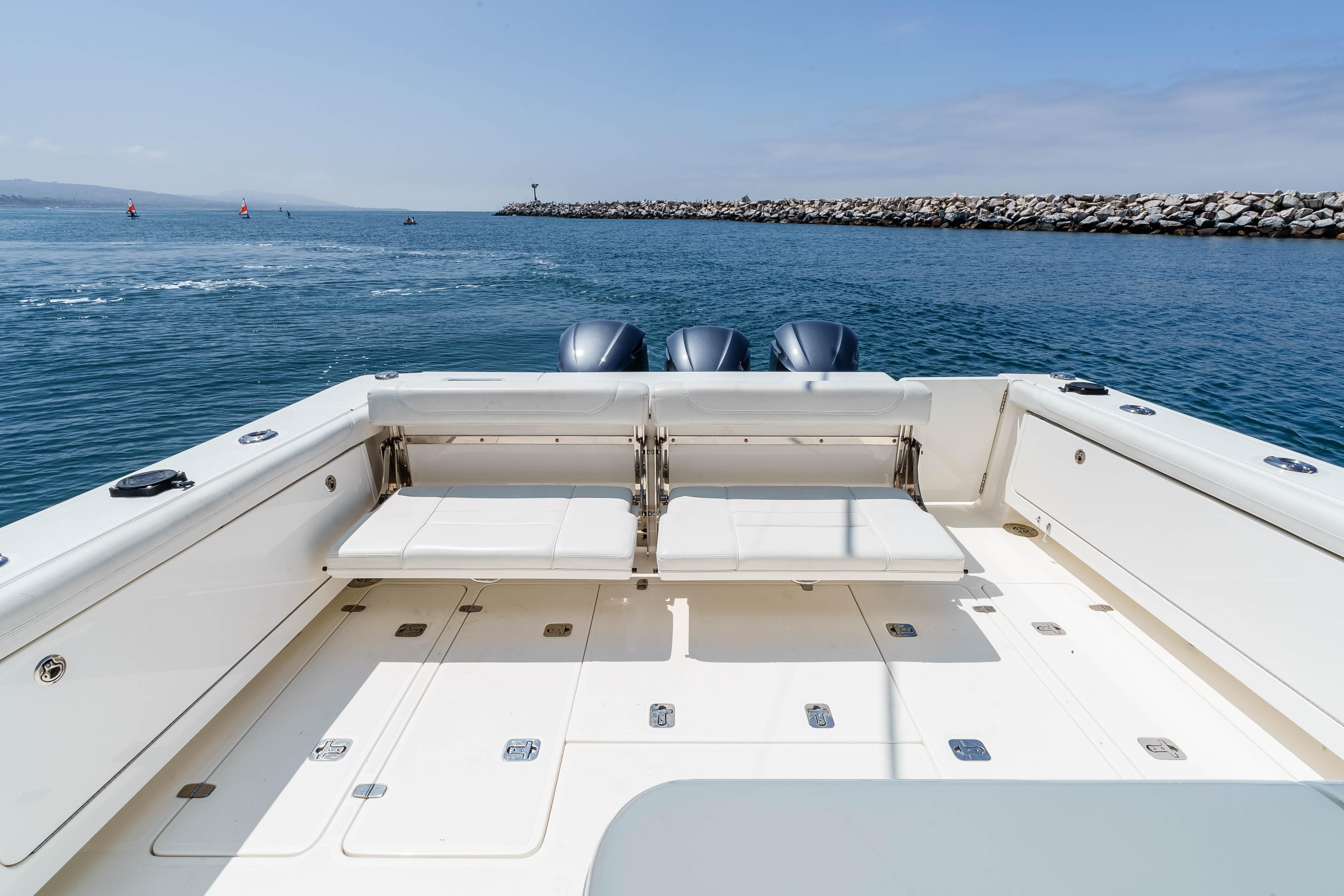 2022 Pursuit OS 385 Offshore boat with spacious deck and triple engines on open water.