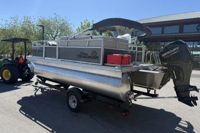 2026 Sun Tracker Bass Buggy 16 XL Select pontoon boat on trailer with Mercury outboard motor.