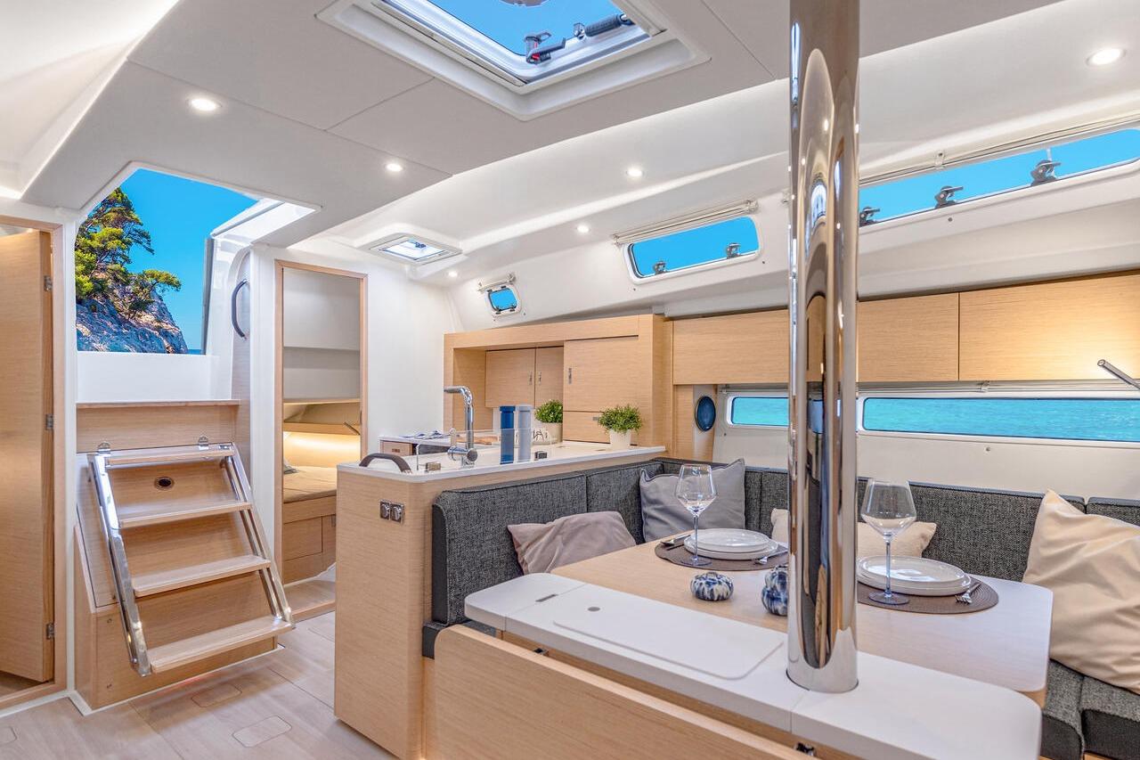 Luxurious interior of 2025 Hanse 360 yacht with modern dining area and scenic views.