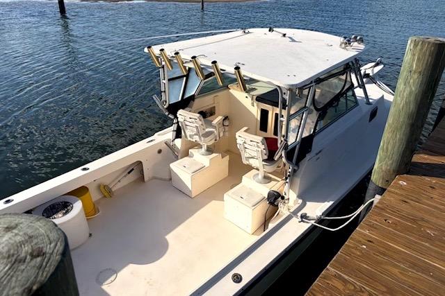 2001 Parker 2510 Walkaround boat docked, featuring spacious deck and dual seating.