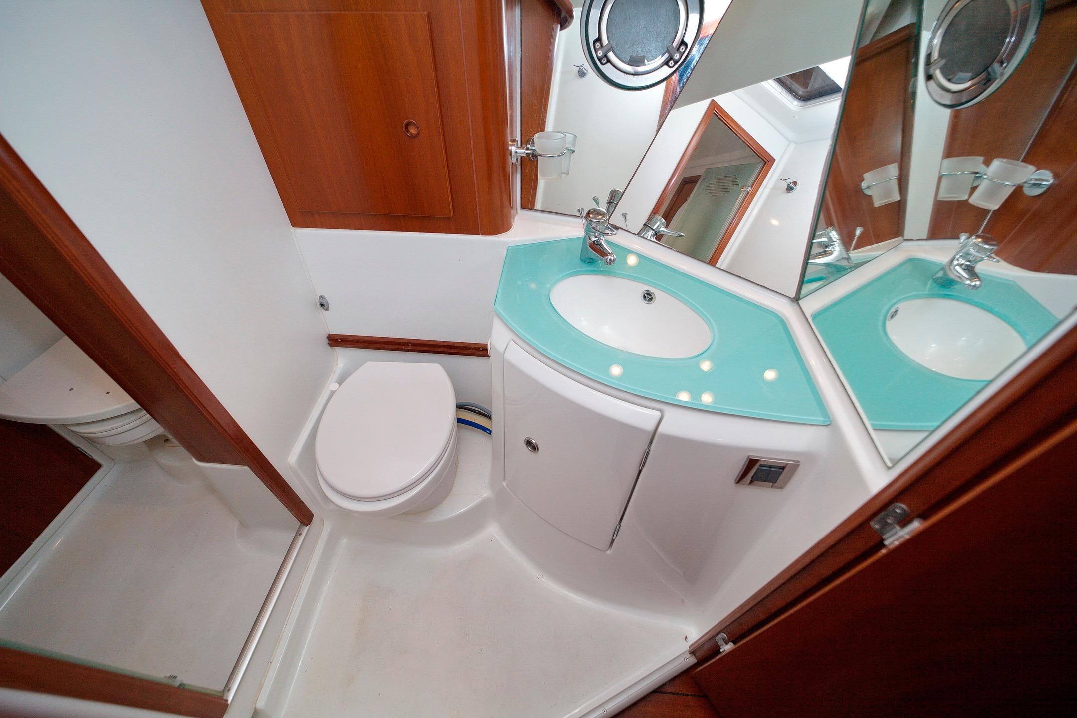 Bathroom interior of 2004 Beneteau Swift Trawler 42 with modern fixtures and wood accents.