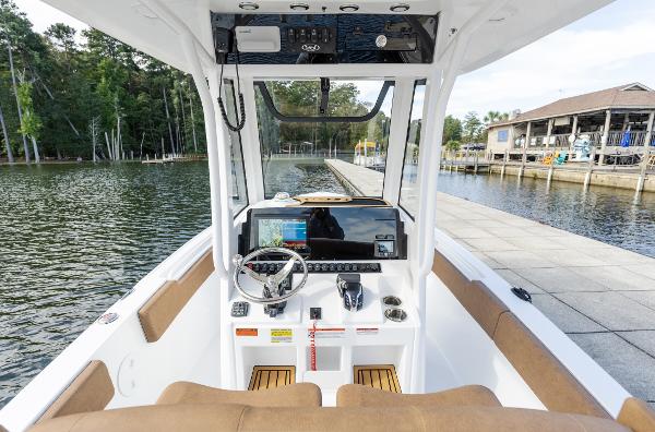 2025 Sea Hunt Ultra 235 SE boat interior with steering console, dockside view.