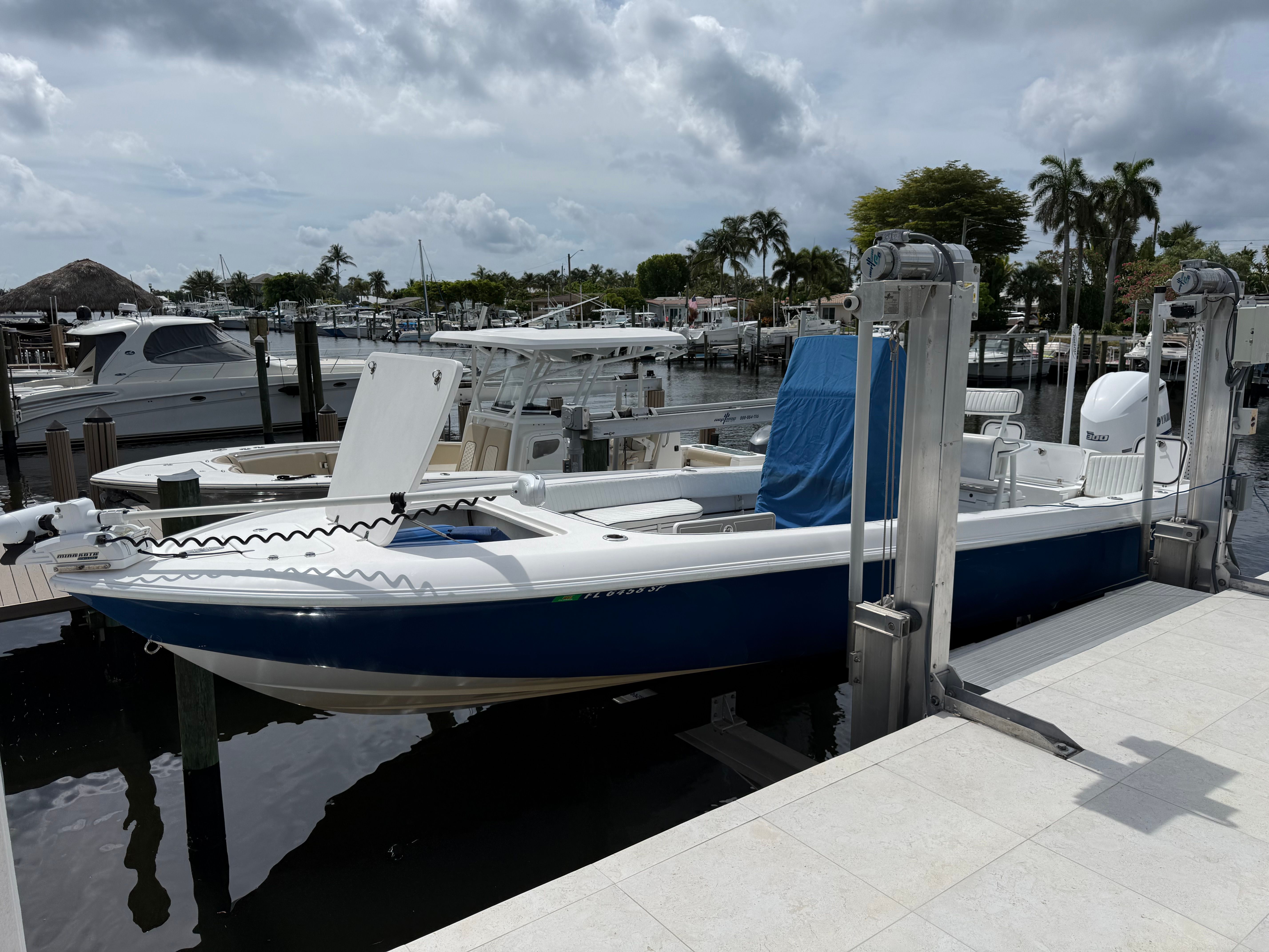 A 2016 Contender 25 Bay boat is docked in a marina, surrounded by other boats.
