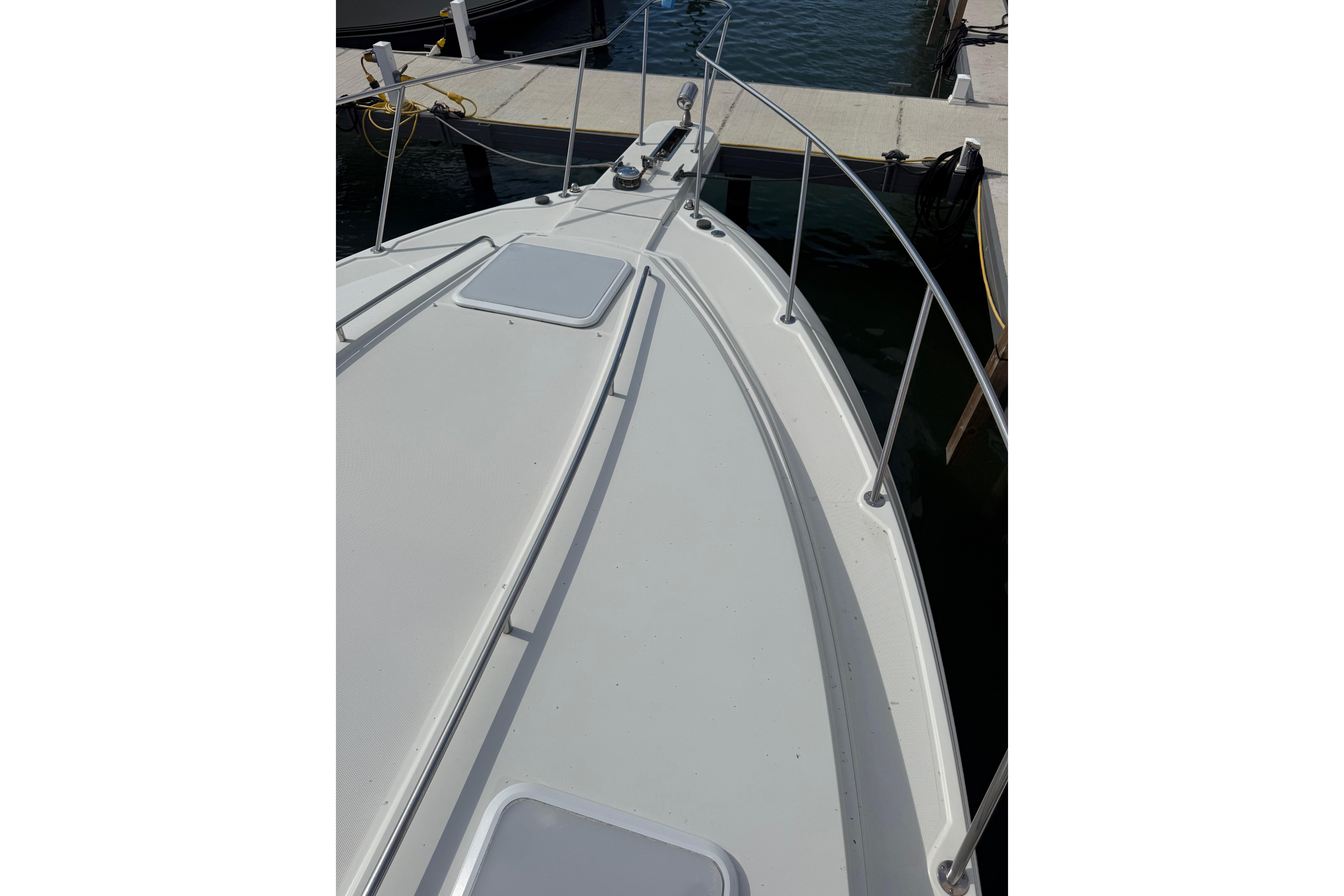 1999 Formula 34 Performance Cruiser docked, showcasing sleek deck design and railing.