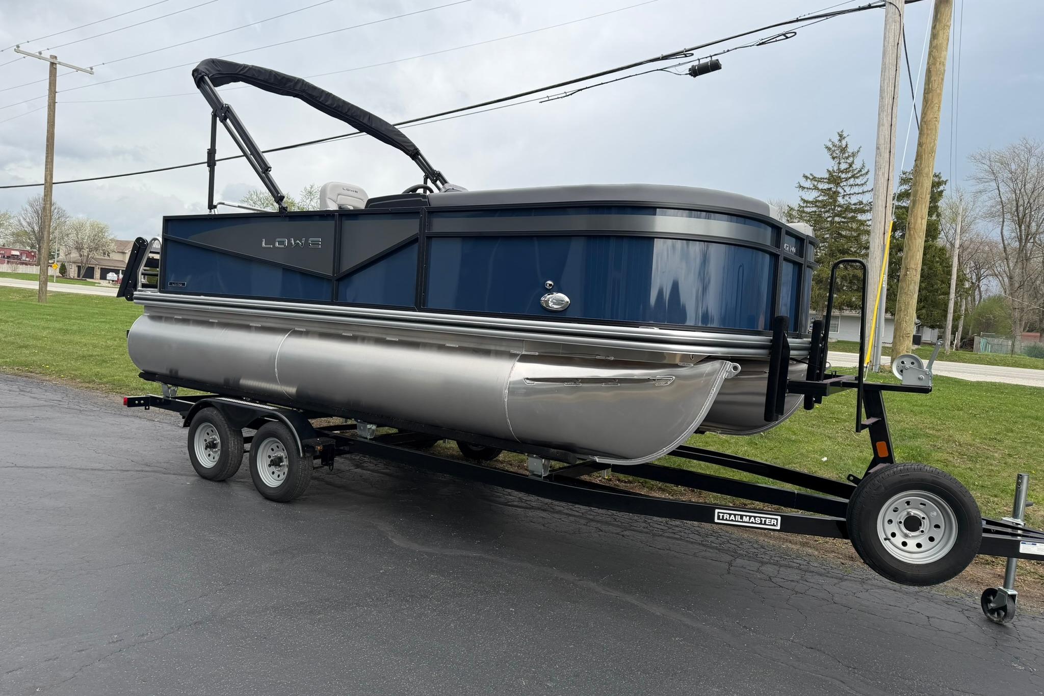 2026 Lowe LS 190 pontoon boat on trailer, parked outdoors on paved surface.