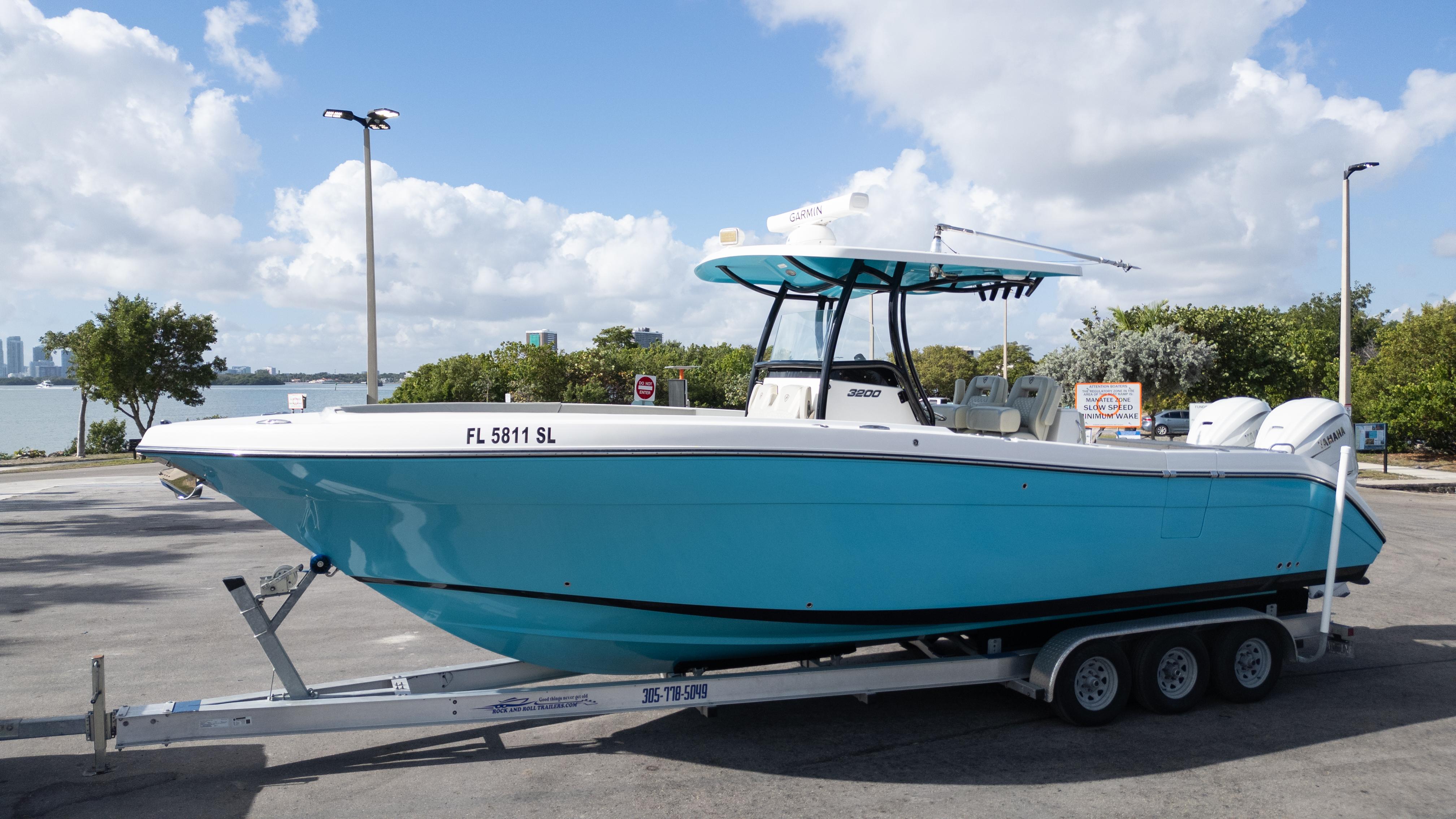 2019 Century 3200 Center Console boat on trailer, parked near waterfront.