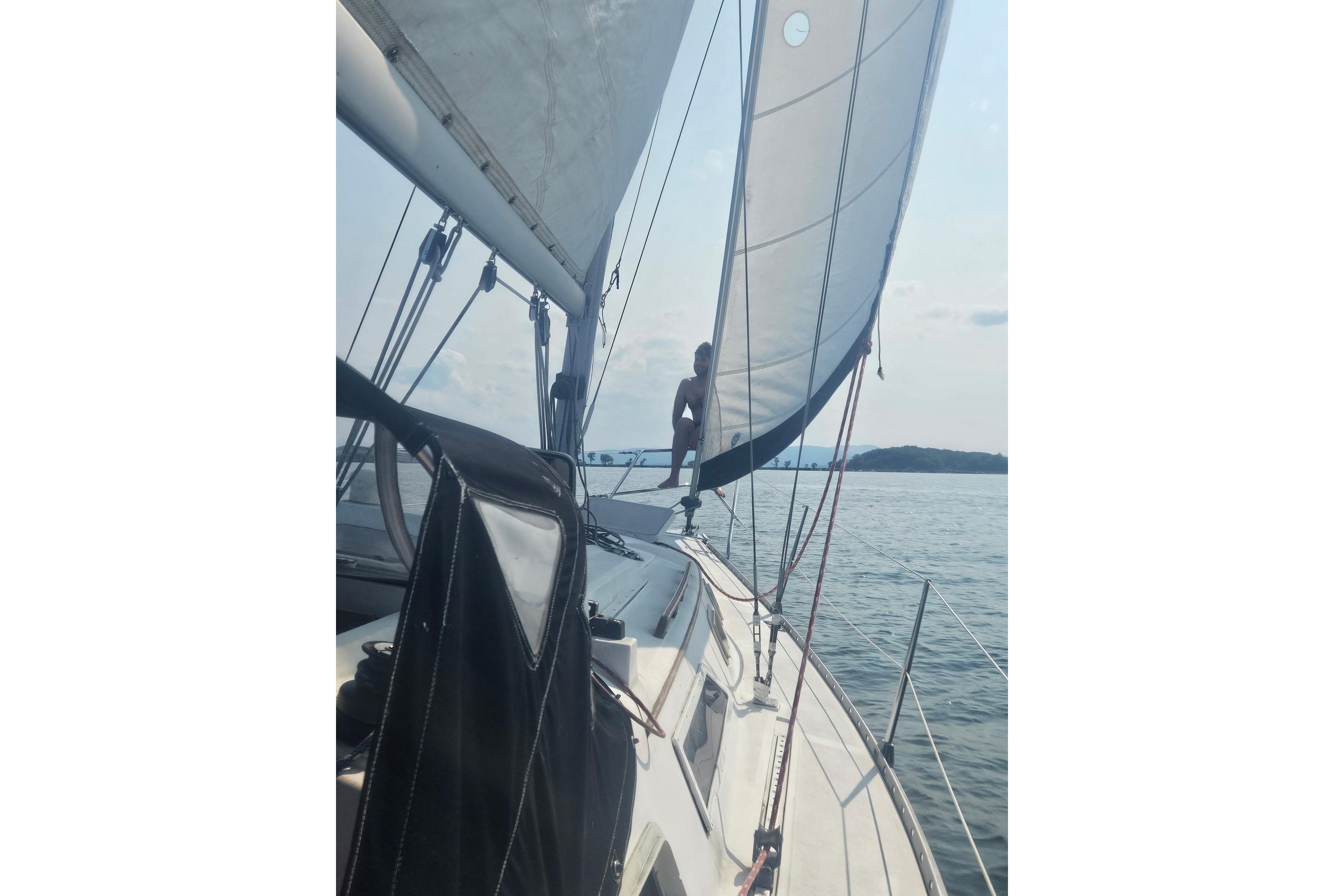 Sailing on a 1985 Hunter 31 yacht with open sails on a calm sea.
