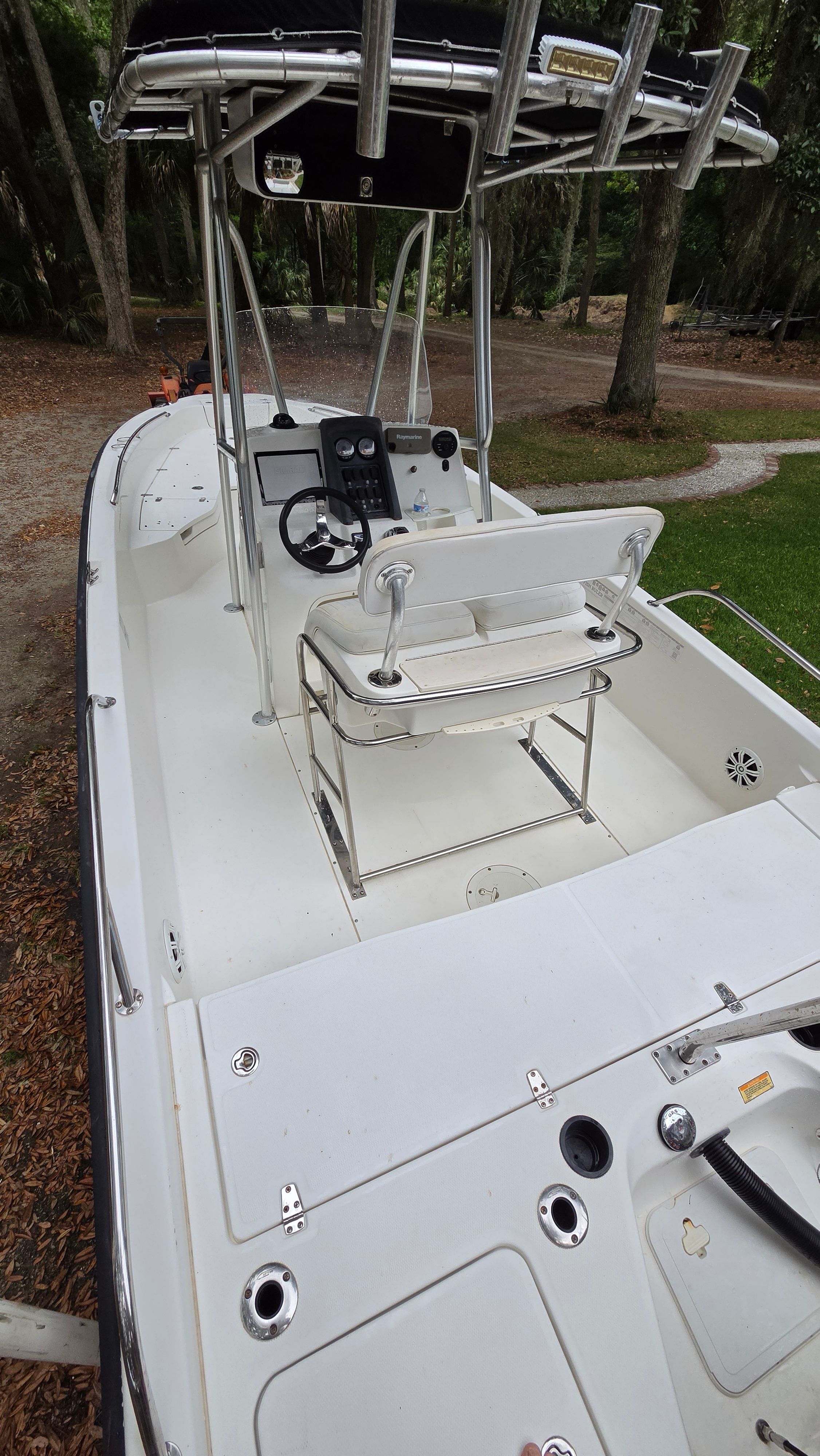 The image shows a 2008 Boston Whaler 230 Dauntless boat with a clean, white deck and helm.