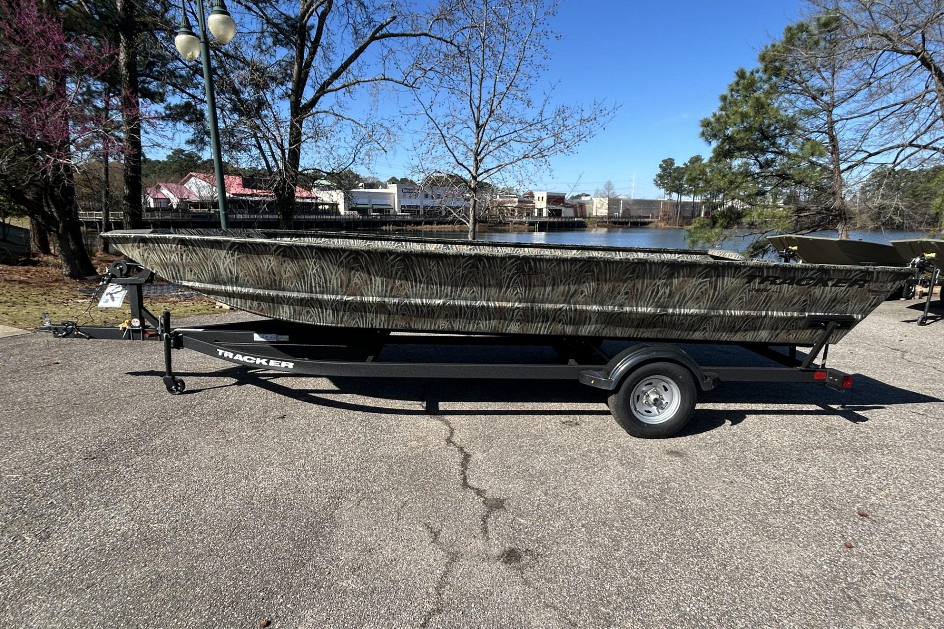 2025 Tracker Grizzly 2072 Utility boat on trailer, parked near a scenic lake.