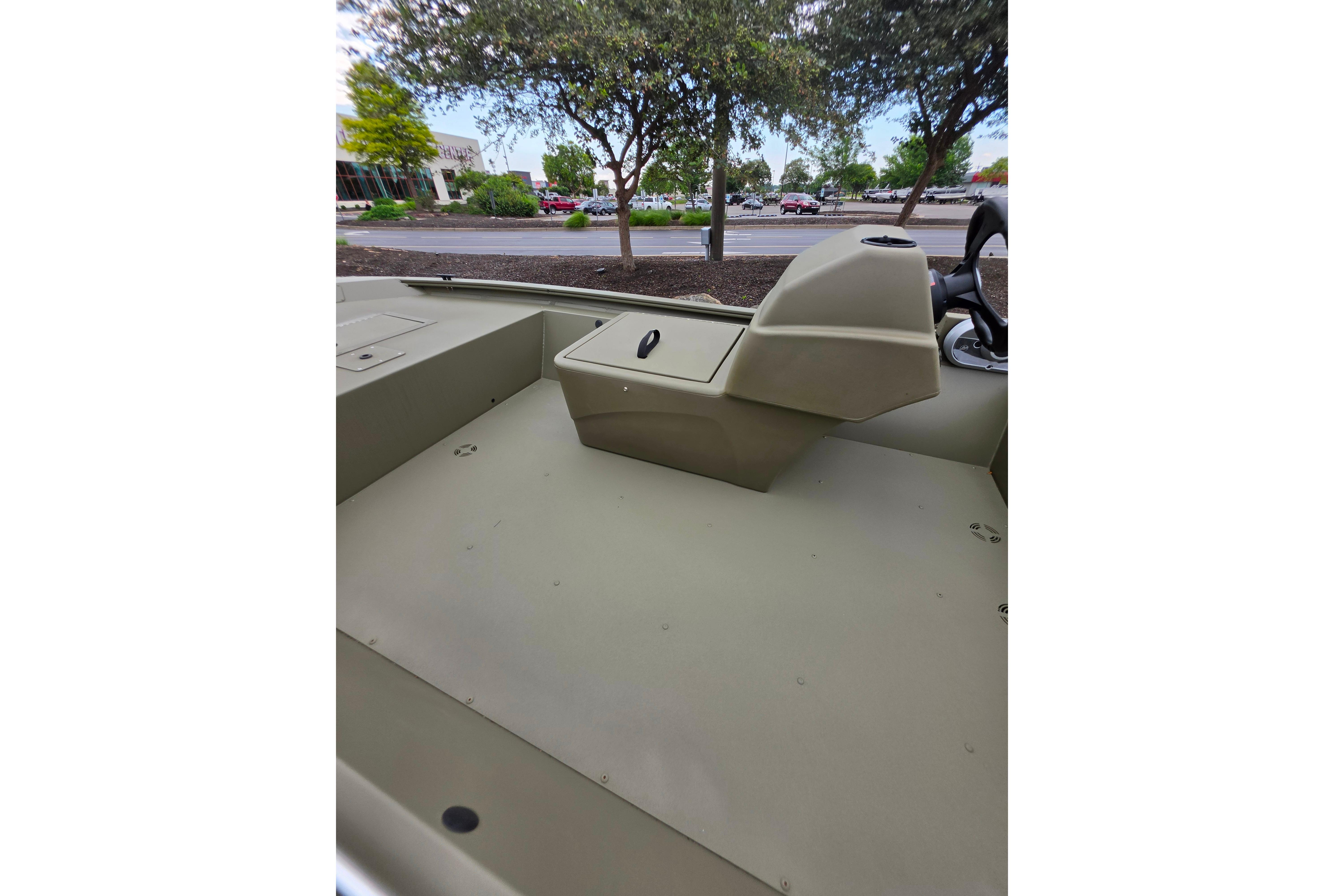 2026 Tracker Grizzly 1648 SC boat interior with console, parked outdoors.