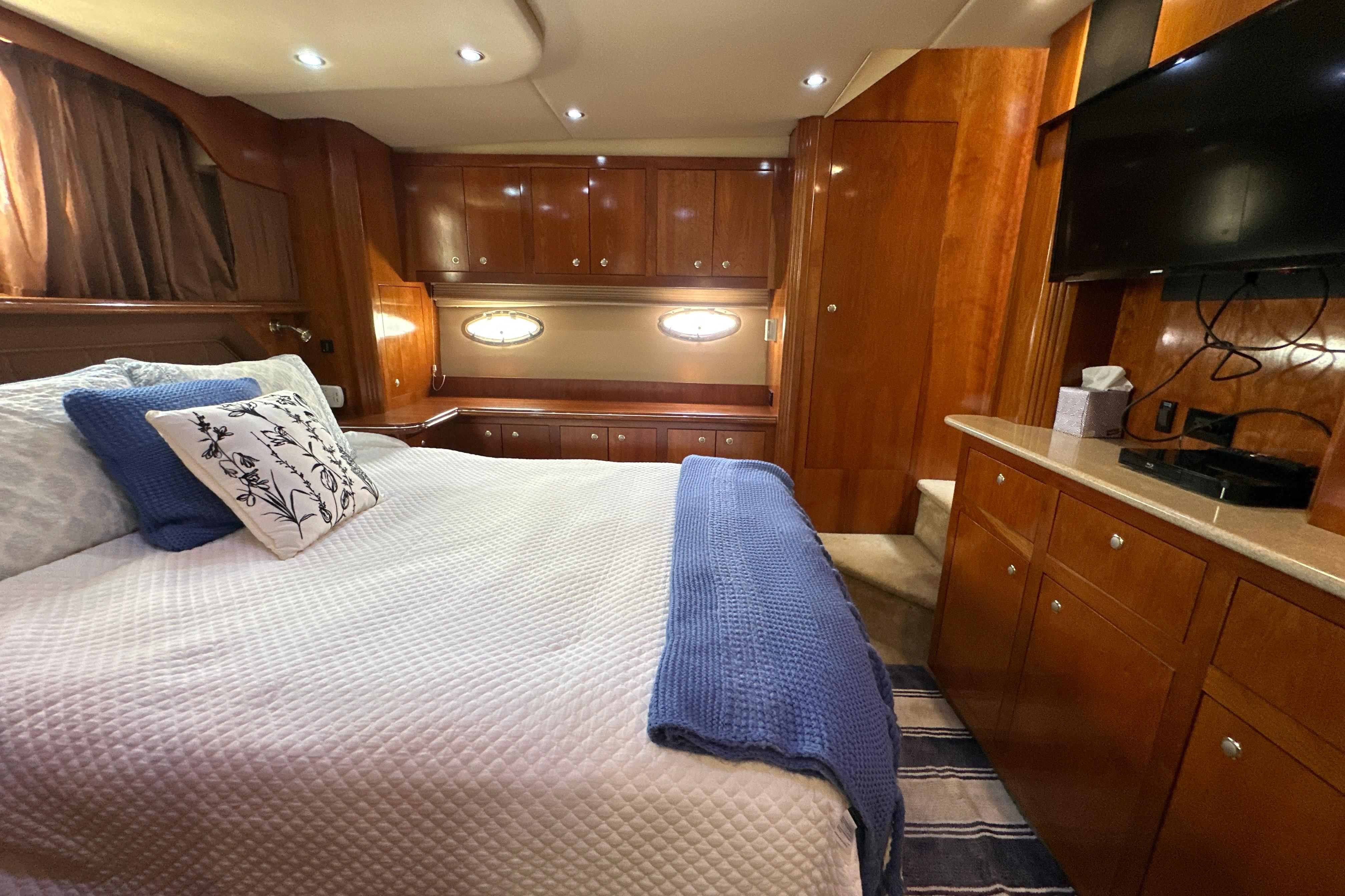 Luxurious 2004 Cruisers Yachts 405 Express Motoryacht bedroom with elegant wood cabinetry.