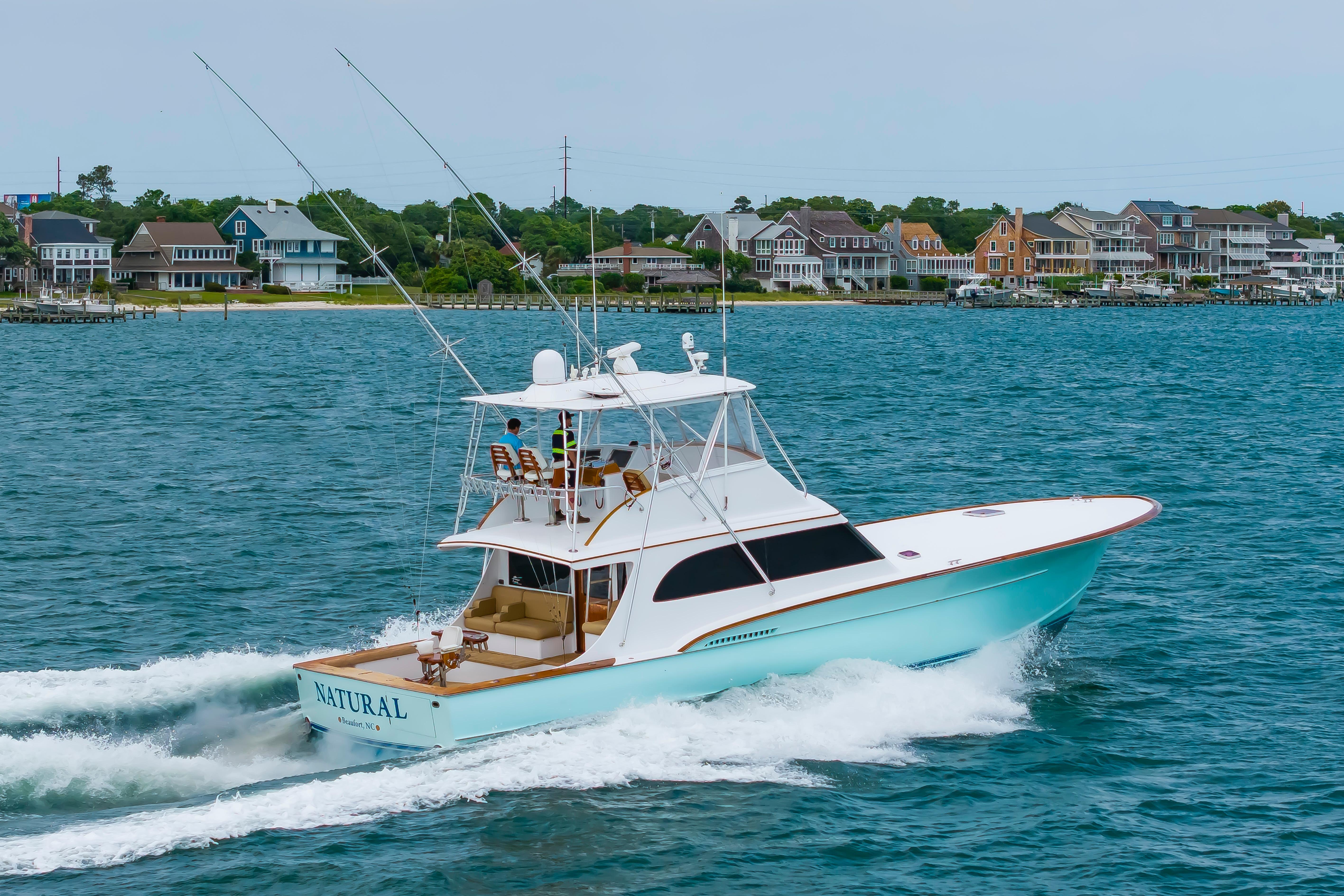 Custom Carolina Scarborough 56 Convertible yacht cruising near coastal homes, 1993 model.