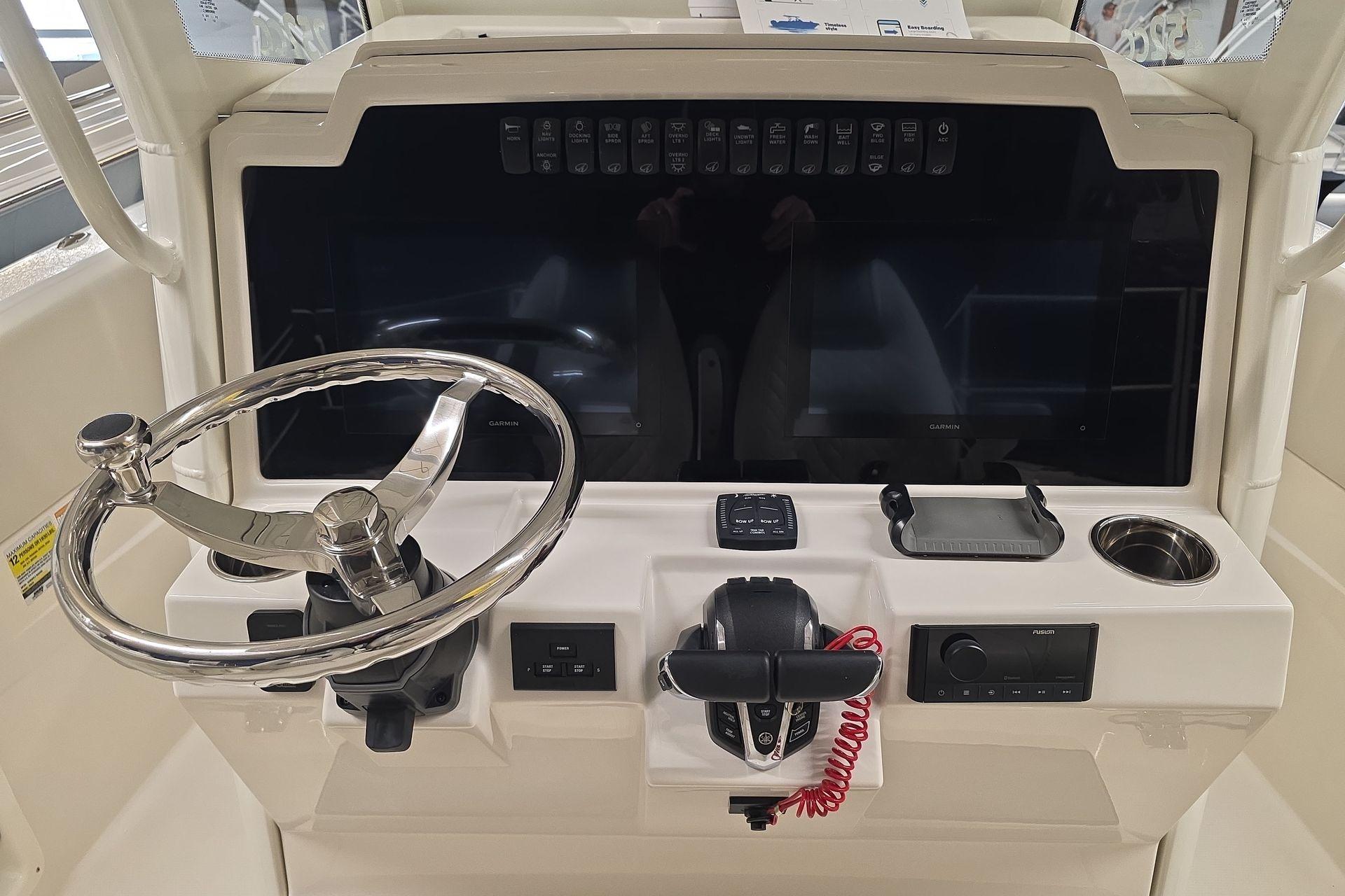 2026 Sailfish 252 CC boat dashboard with steering wheel and control panel.