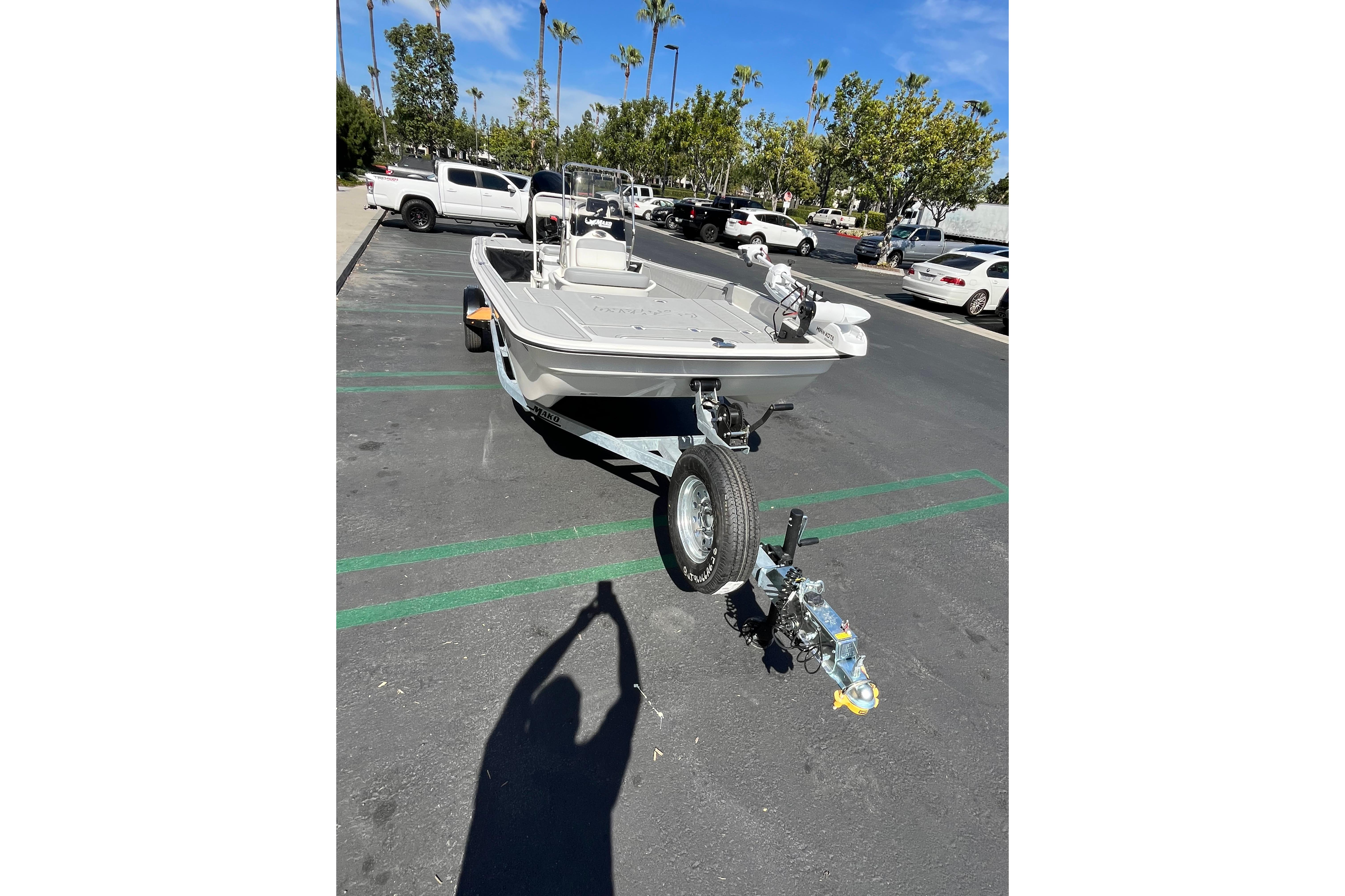 2026 Mako Pro Skiff 17 CC boat on trailer in parking lot, sunny day.