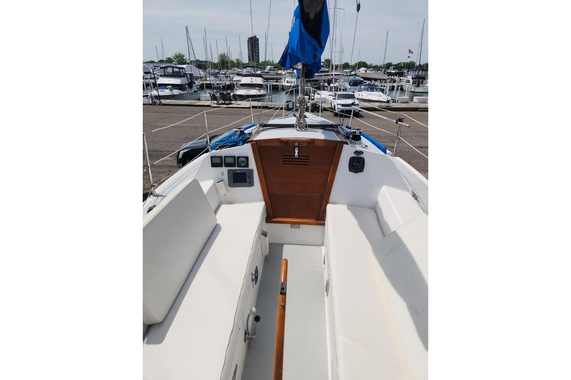 1990 Catalina Capri sailboat cockpit with white seating, docked at a marina.