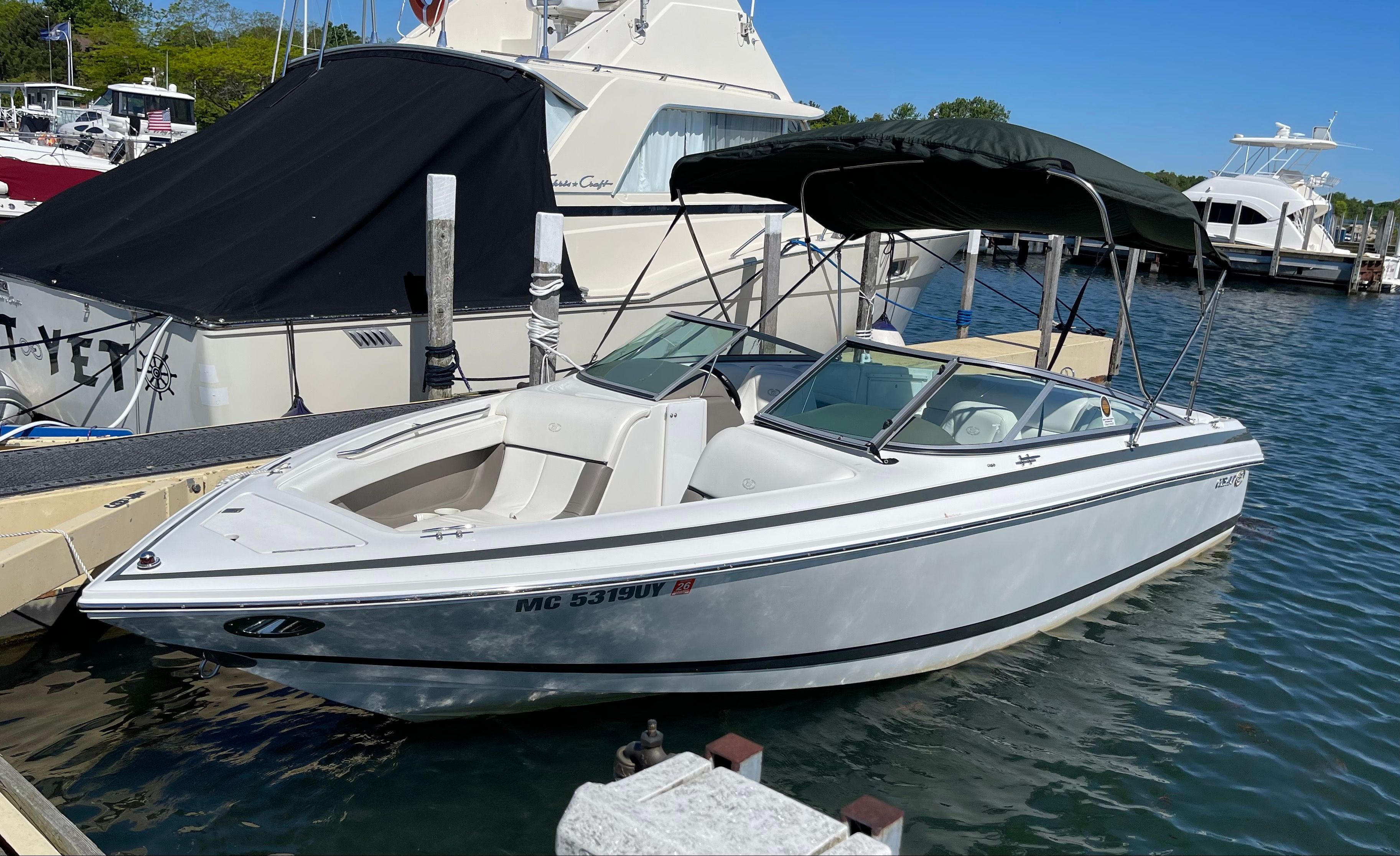 A white 2001 Cobalt 226 boat is docked on the water.