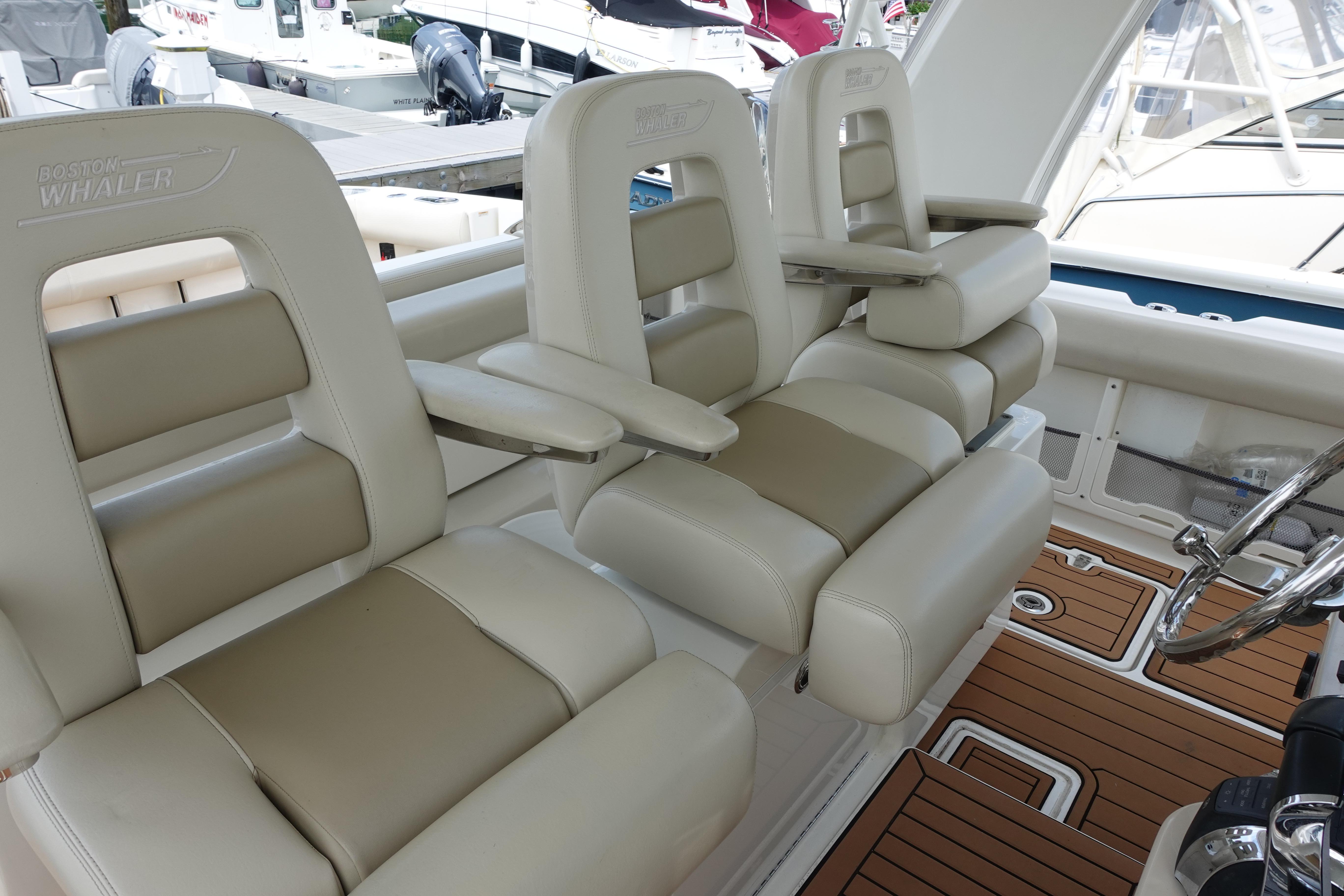 Luxury seating on a 2020 Boston Whaler 420 Outrage boat, featuring plush armchairs.